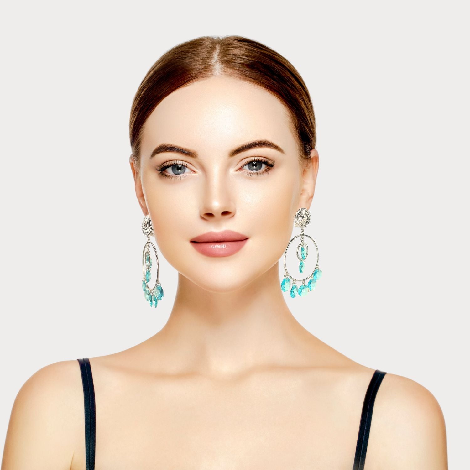 The Starshine Chandelier Clip On Earrings by JAREDJAMIN Jewelry Online feature silver hoops with round studs, a central blue faceted bead, and five Swarovski crystals dangling below for a sparkling chandelier look.