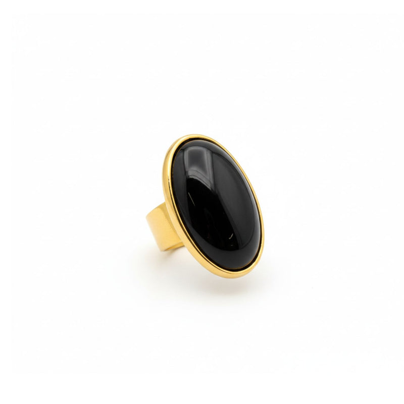 Stella ステートメント リング in ブラック Agate JAREDJAMIN製 ジュエリーオンライン 特徴とする a large, 磨き上げた オーバル stone in an 18Kゴールドプレート bezel 付きの wide, adjustable band, shown against a plain 白い背景.