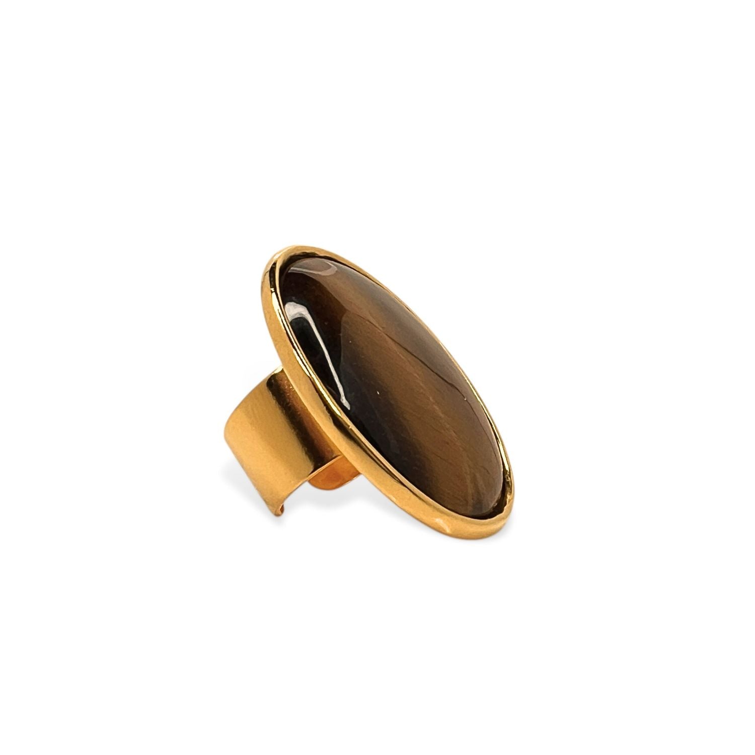 The Stella Statement Ring in Tiger's Eye by JAREDJAMIN Jewelry Online features an oval Tiger's Eye cabochon with lighter streaks, set in a smooth bezel on a wide 18K gold-plated band, shown against a white background.