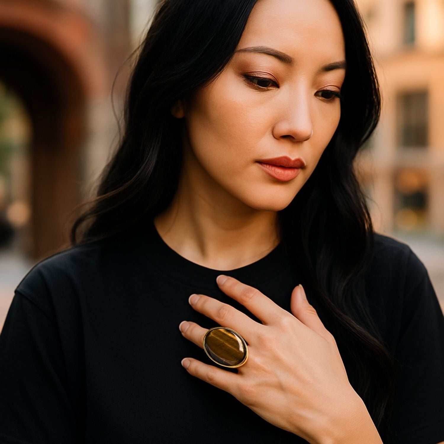 The Stella Statement Ring in Tiger's Eye by JAREDJAMIN Jewelry Online features an oval Tiger's Eye cabochon with lighter streaks, set in a smooth bezel on a wide 18K gold-plated band, shown against a white background.