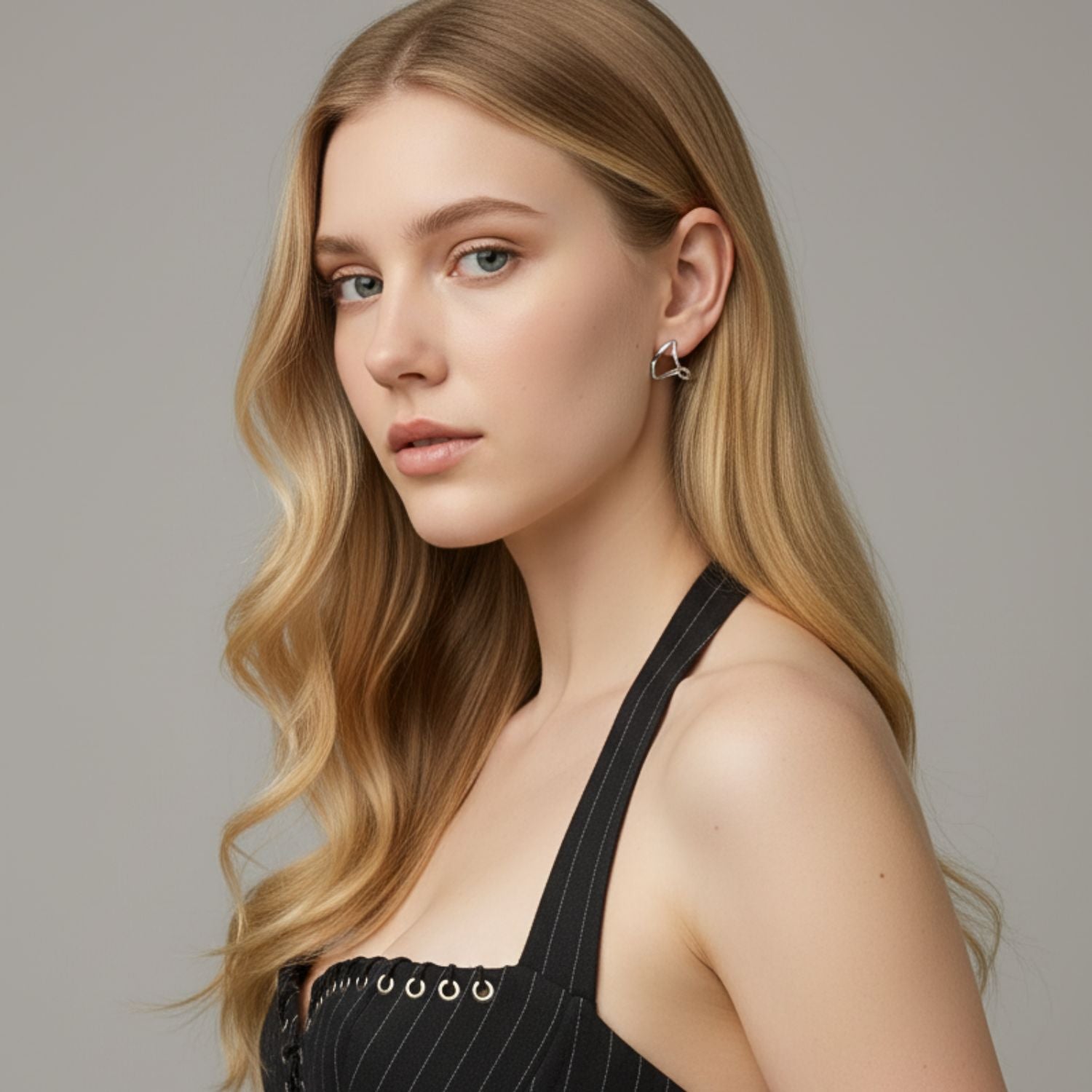 Tabby Earrings by JAREDJAMIN Jewelry Online: 18K Gold abstract twisted loops, each double hoop forming an open, asymmetrical triangle with a shiny, reflective finish that casts a soft shadow on a white background.