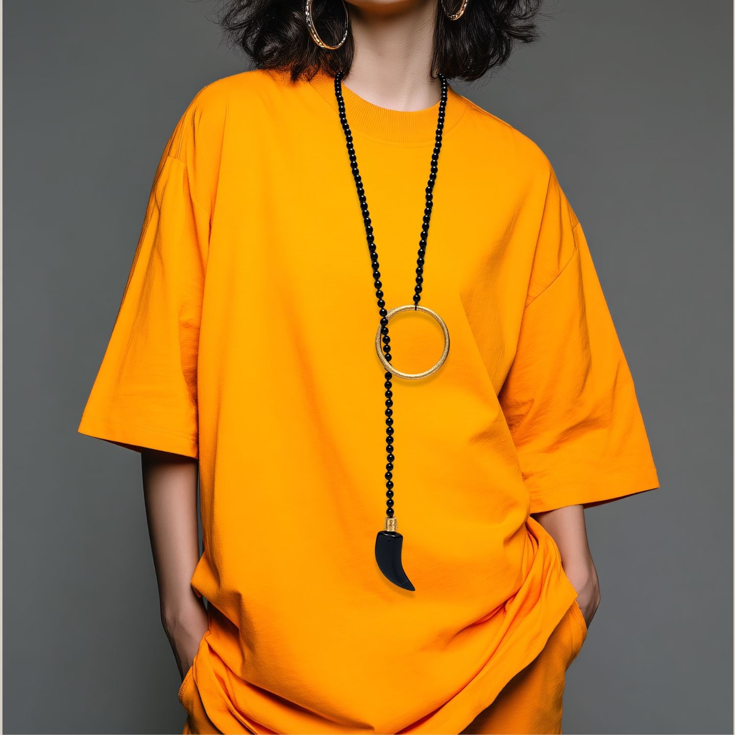 The Tucan Tusk Onyx Necklace by JAREDJAMIN Jewelry Online is a bold 45-inch knotted strand with black beads, an 18K gold plated ring, and an agate tooth-shape pendant with gold cap—striking against a white background.