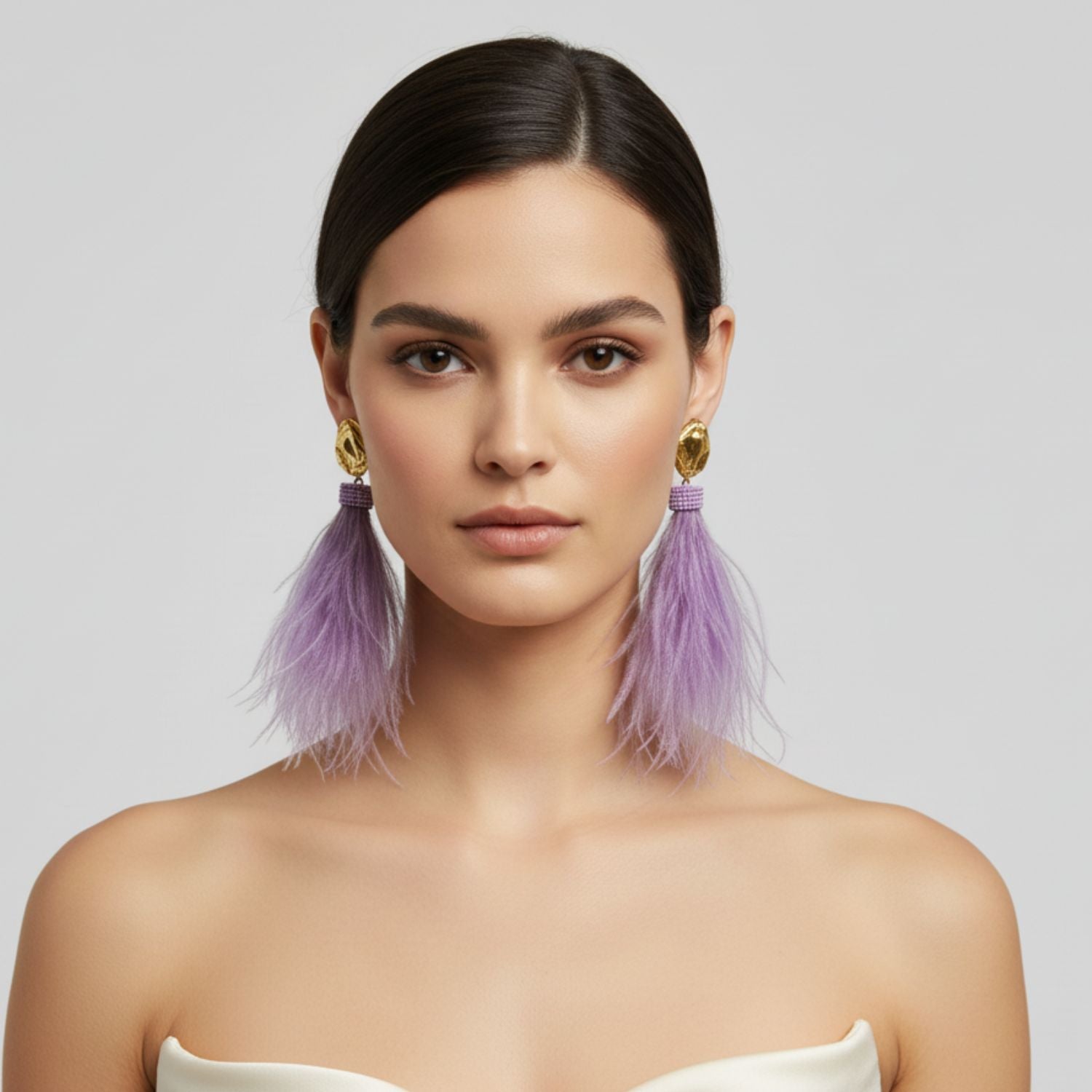 The Vegas Vixen Clip-On Earrings from JAREDJAMIN Jewelry Online showcase gold-tone studs, cascading lavender feather strands, and a band of small purple beads for an elegant, whimsical look with soft movement.