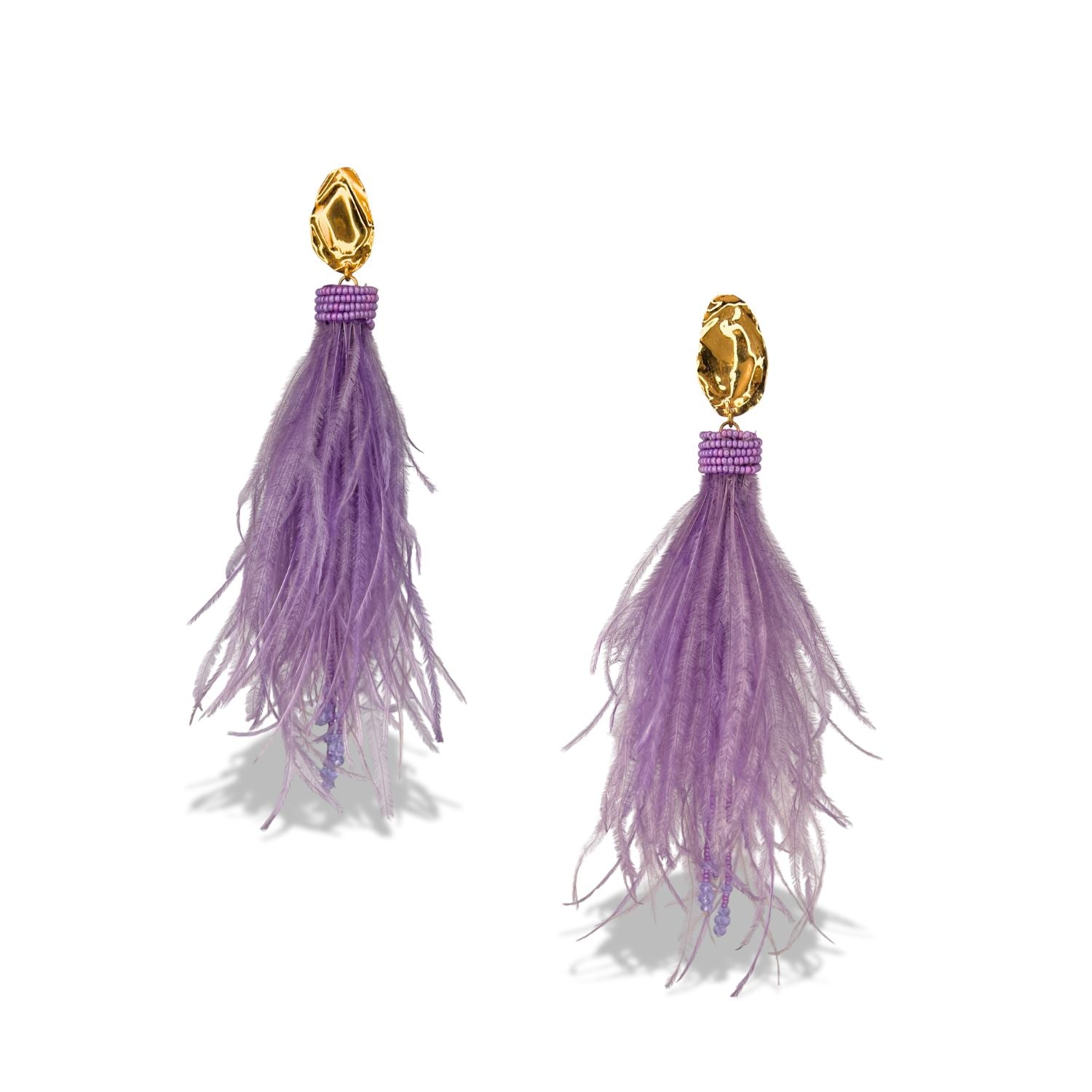 The Vegas Vixen Clip-On Earrings from JAREDJAMIN Jewelry Online showcase gold-tone studs, cascading lavender feather strands, and a band of small purple beads for an elegant, whimsical look with soft movement.