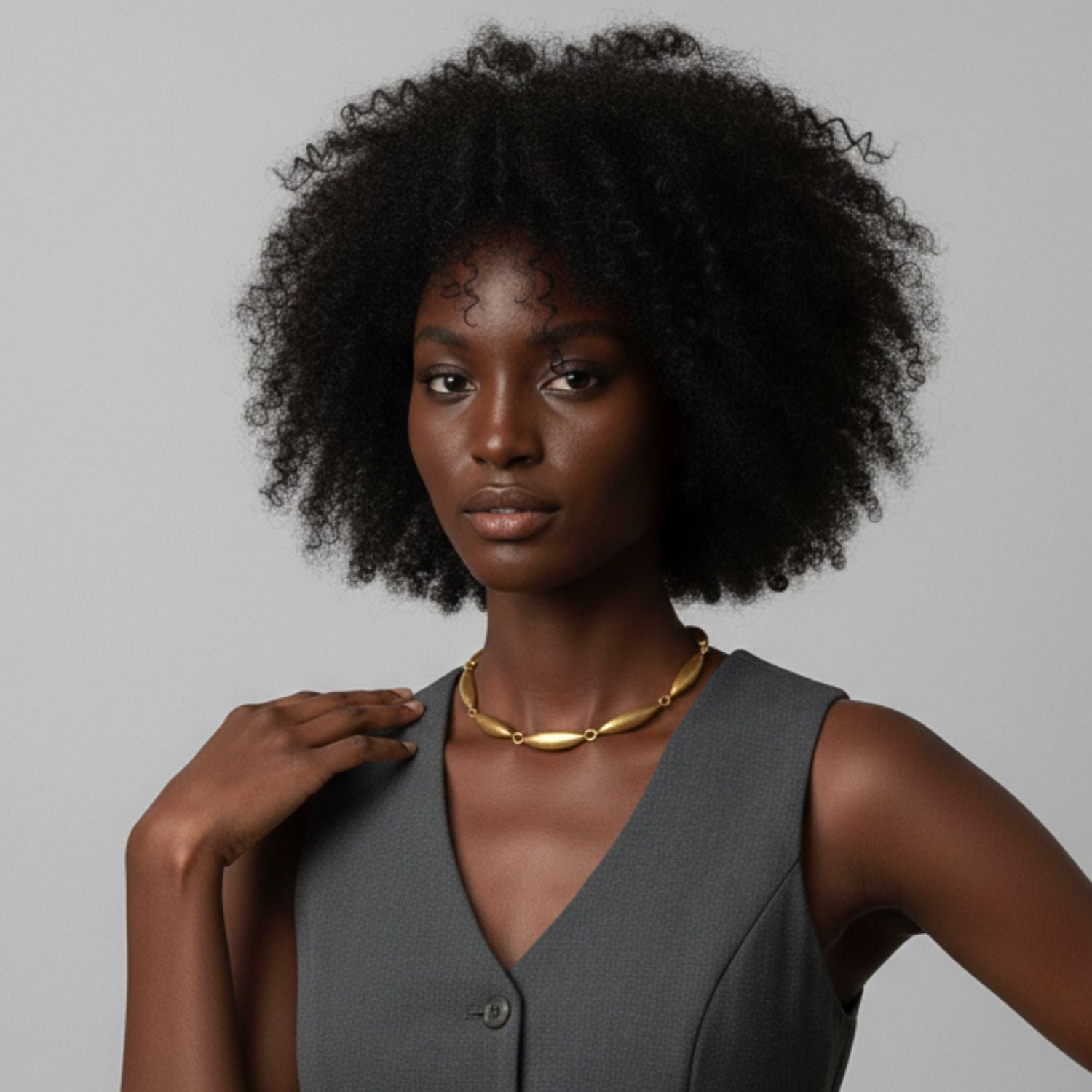 The Zeppelin Phoebe Gold Necklace by JAREDJAMIN Jewelry Online features eight elongated, textured oval links and small round rings, finished in matte gold with a toggle clasp and rectangular tag for vintage flair.