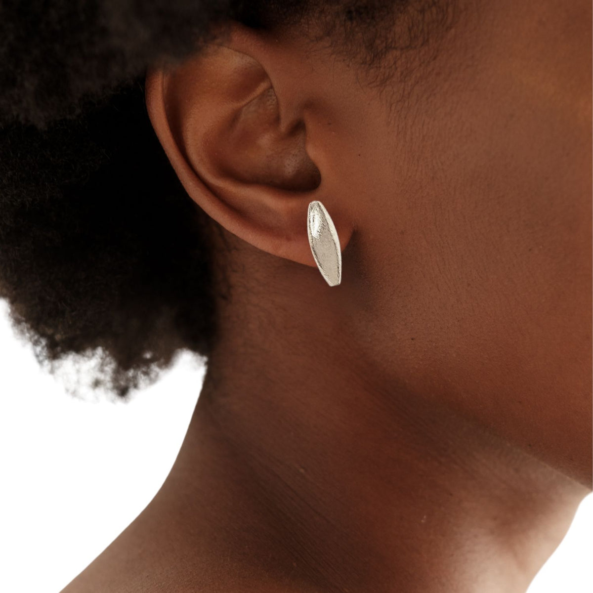 Small, leaf-shaped argent Zeppelin puce Post boucle d'oreille par JAREDJAMIN, crafted in argent avec a brushed finish. Artisanal Craftsmanship Small-batch/West Hollywood, Sustainable de luxe, Signature Texture. Softly blurred fond blanc.