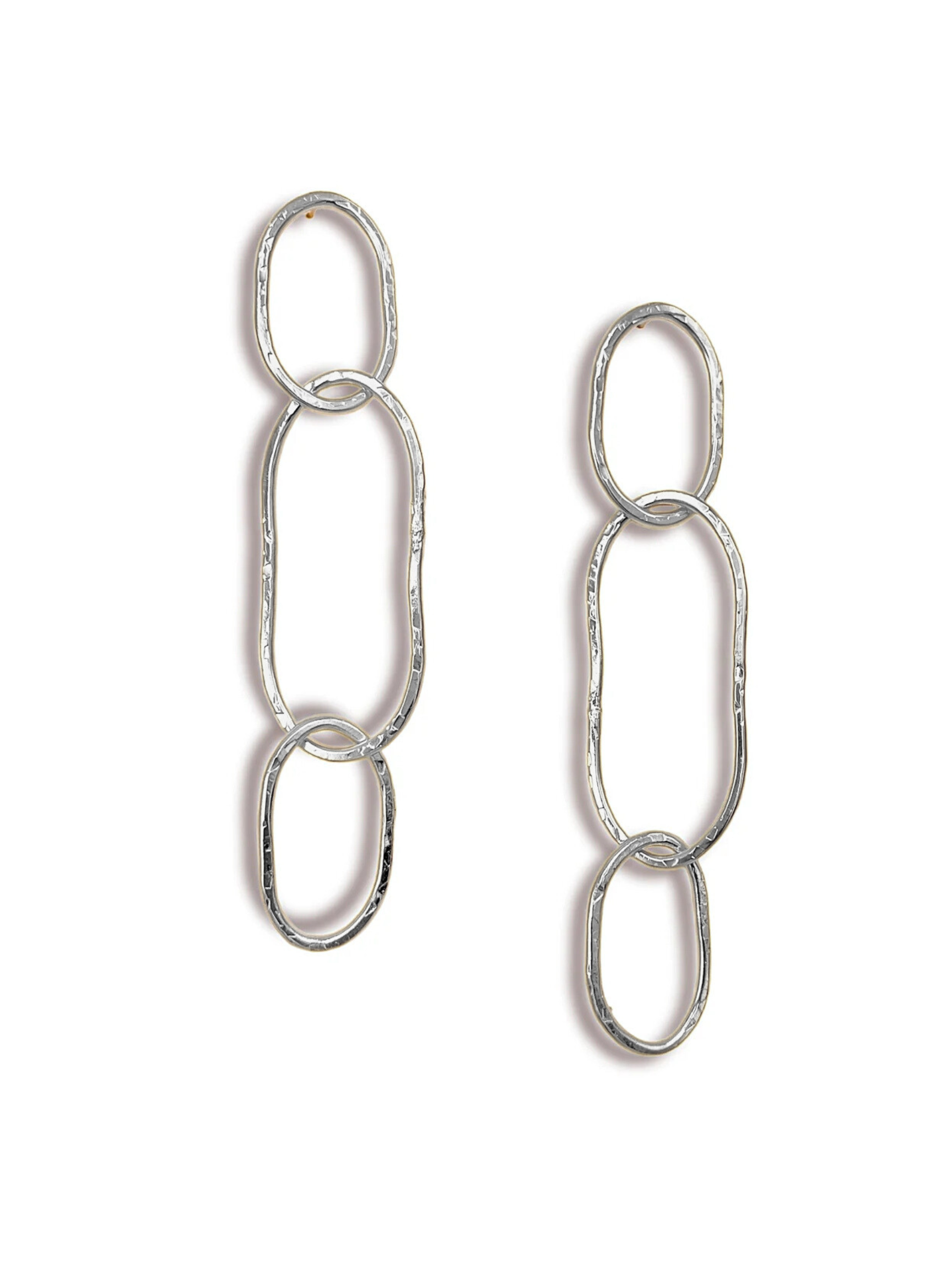 The Shackle Link Dangle Post Earrings from JAREDJAMIN Jewelry Online feature two elegant silver hammered texture earrings with three vertically linked ovals of varying size and shape for an organic, handcrafted appearance, laid flat against a white background.