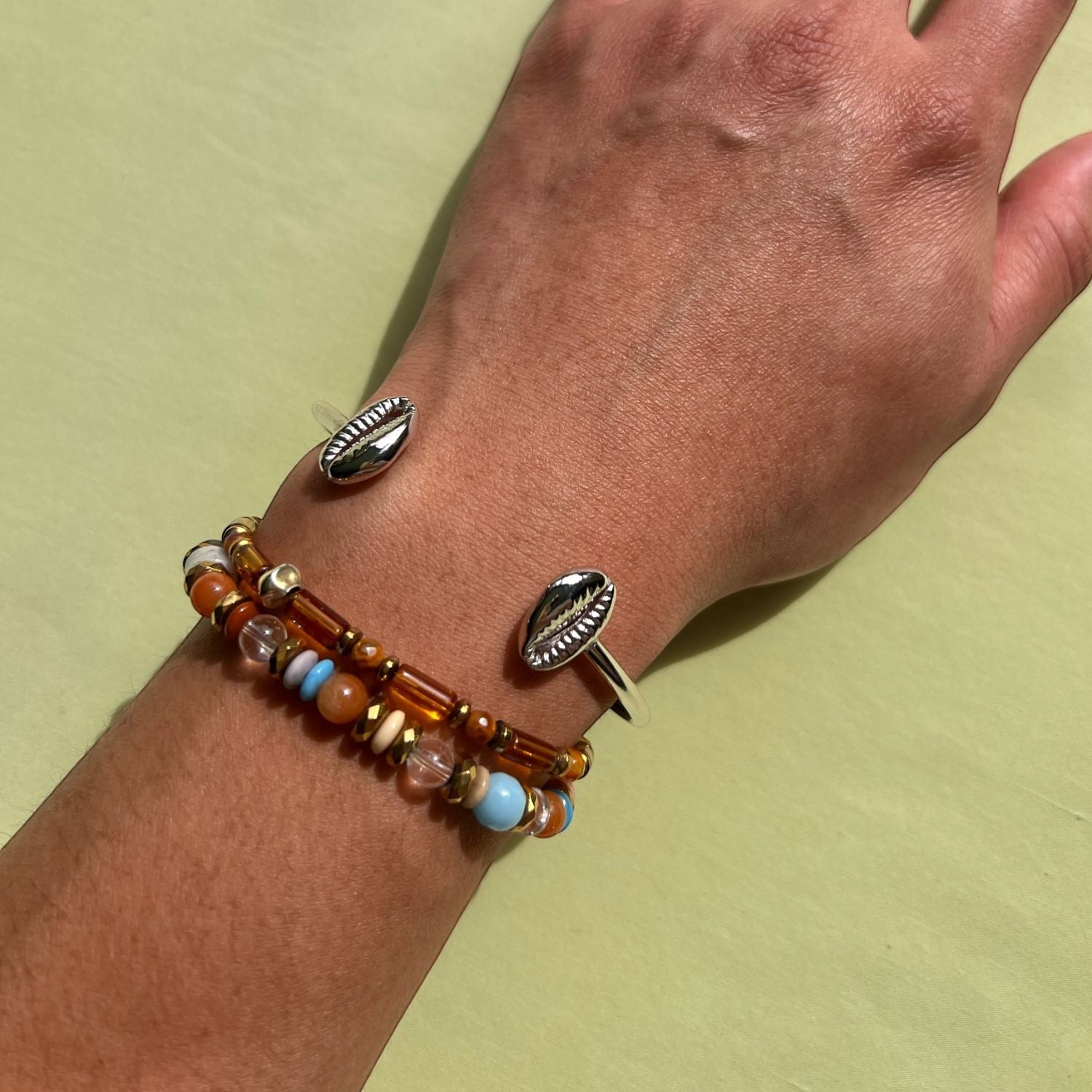 The JAREDJAMIN Jewelry Online Silver Cowrie Shell Cuff Bracelet features two detailed cowrie shell ends on a minimalist silver band, displayed against a plain white background.