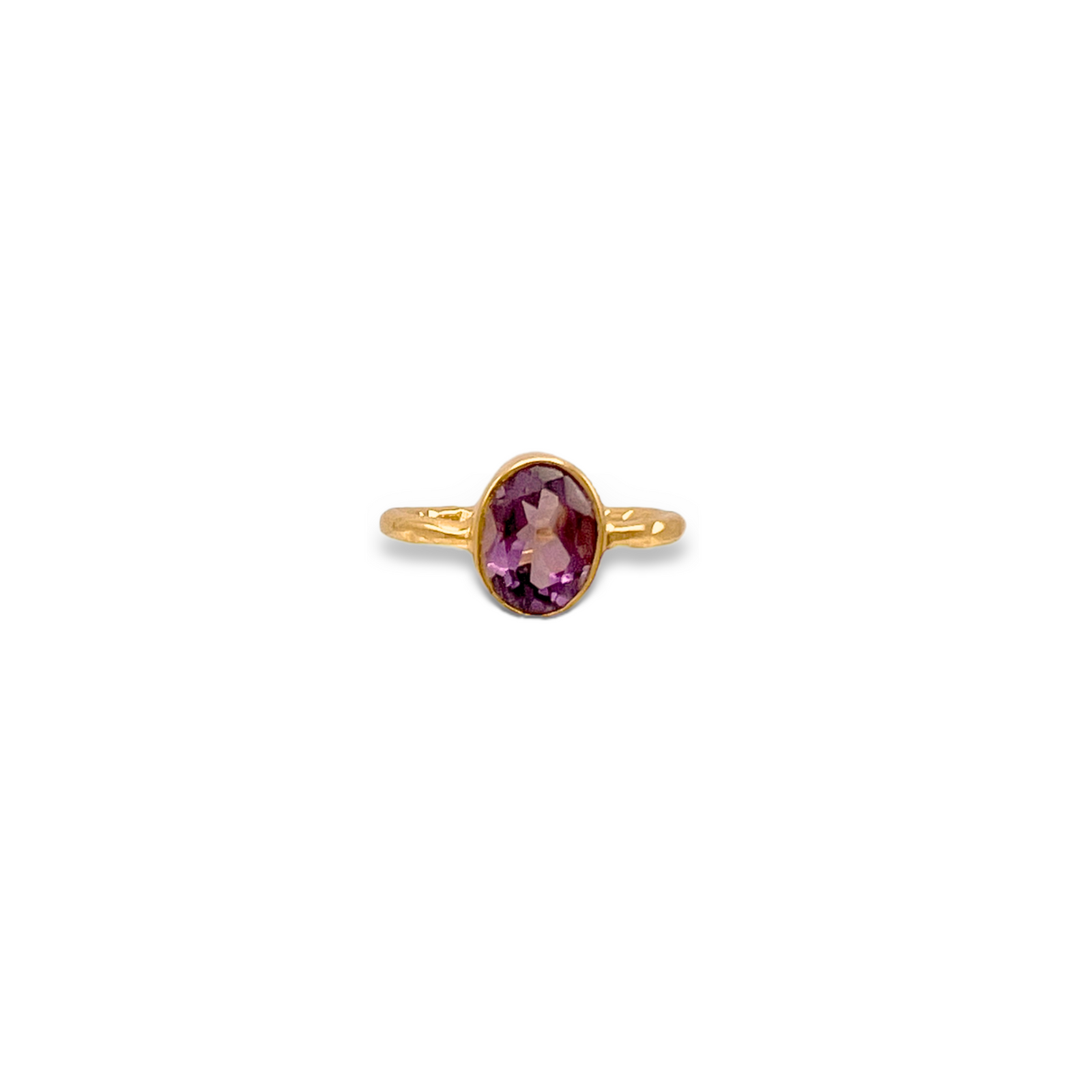 The Oval Amethyst Gemstone Ring by JAREDJAMIN Jewelry Online features a smooth gold band with an oval amethyst center, shown against a plain white background to highlight its vivid color and elegant simplicity.