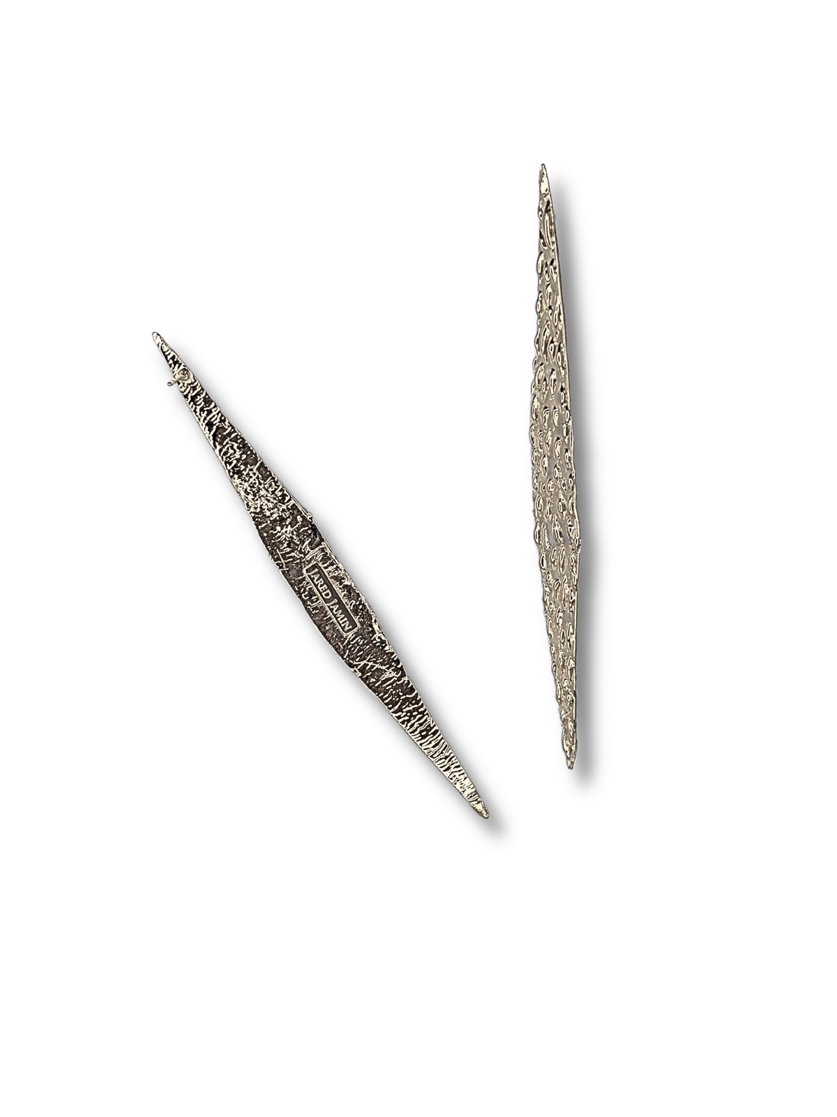 The Jaguaretê Earrings by JAREDJAMIN Jewelry Online are presented against a white background, showcasing their intricate lace-like texture and pointed tips. These elongated silver pieces vary in thickness, suggesting both ornamental and possible functional uses in decorative art.