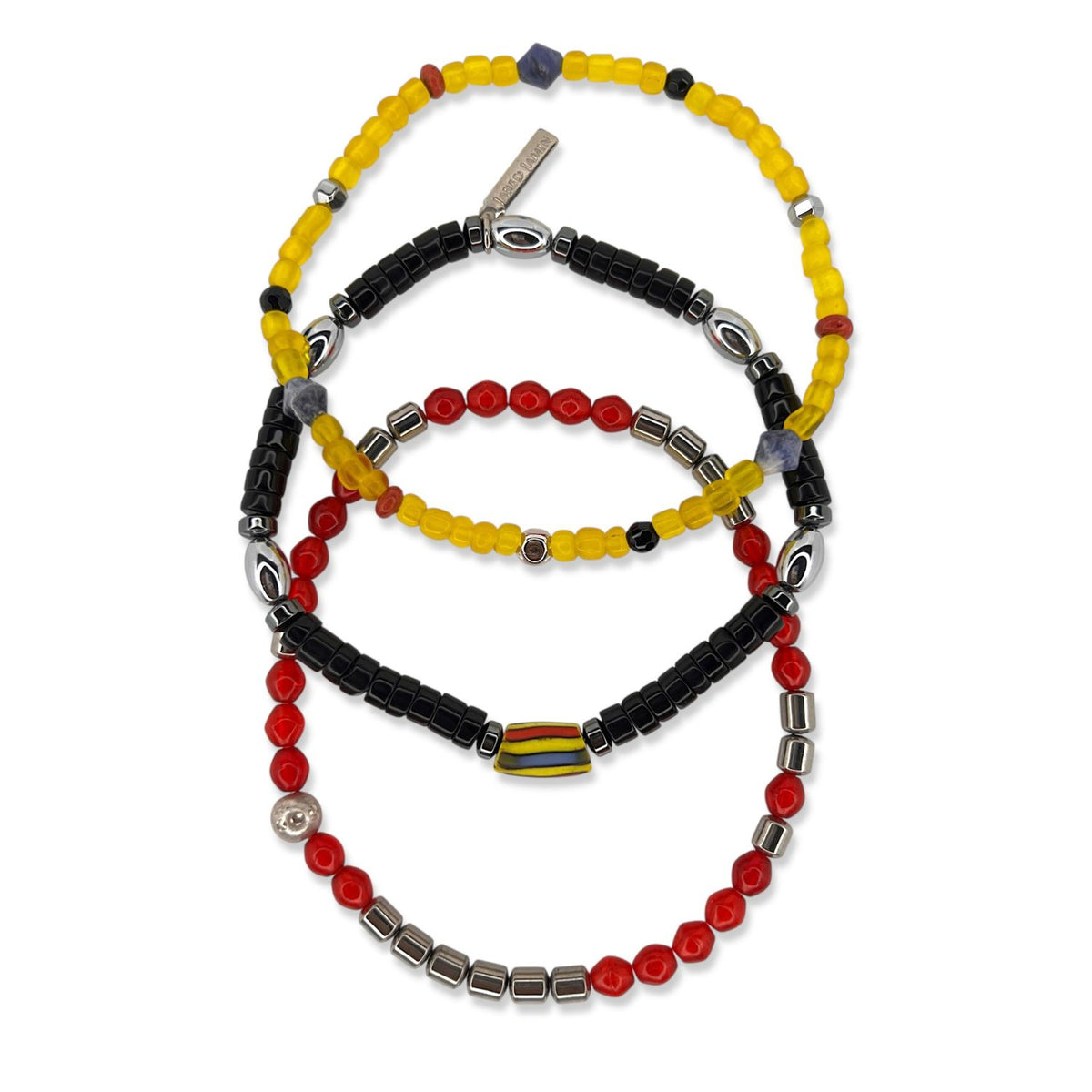 Samurai ブレスレット Set JAREDJAMIN製 ジュエリーオンライン 特徴とする three stretch ブレスレット—yellowとaccentsとan engraved tag, ブラックとシルバーとレッド beads,とレッドとスクエア シルバー spacers—displayed in overlapping circles の上の 白い背景.
