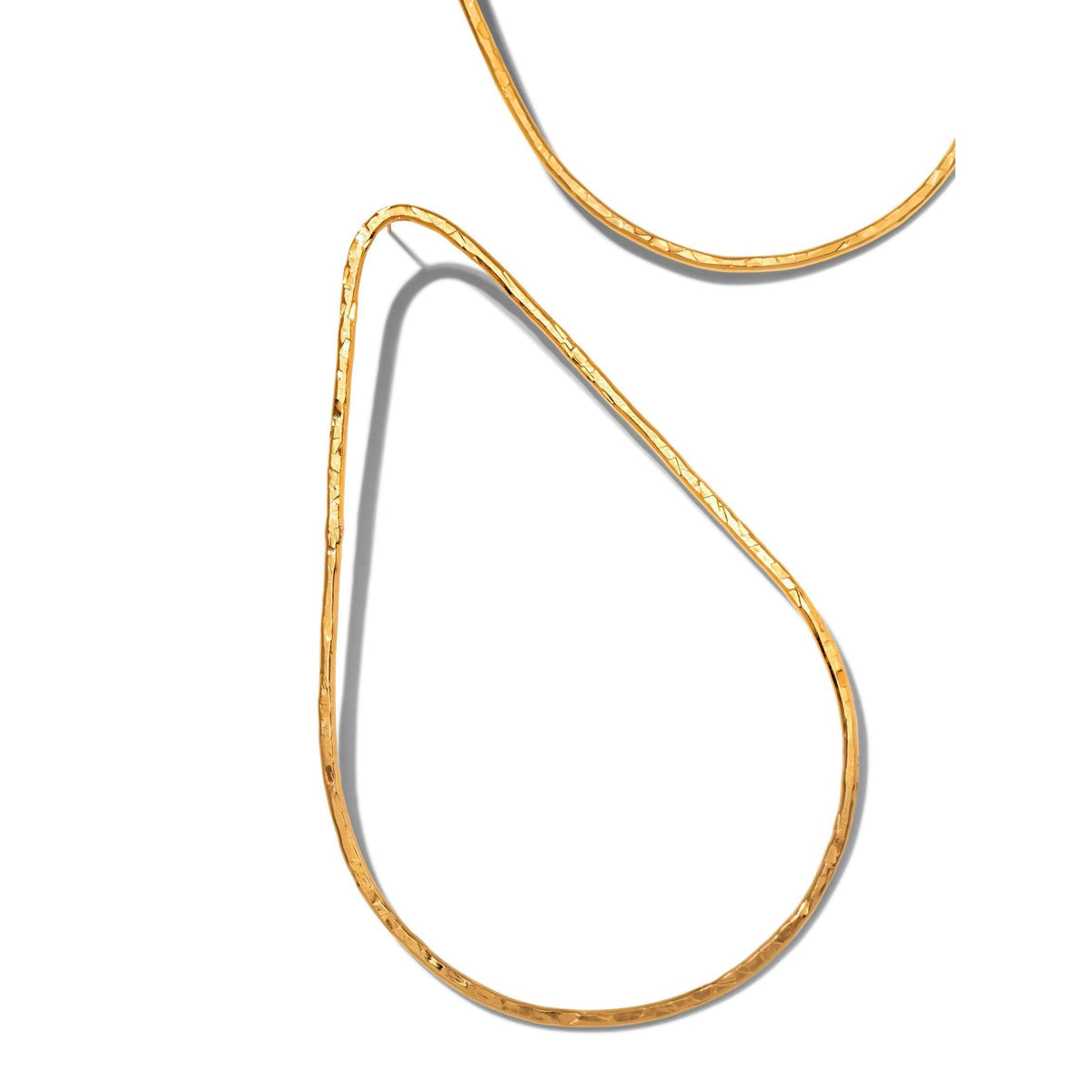 Los Tereza Tear Post pendientes de JAREDJAMIN Joyería Online presentan slender, hammered 18K bañado en oro teardrop silhouettes con light-reflecting texture. Shown partially sobre un fondo blanco, each pendiente’s unique uneven finish catches the eye.