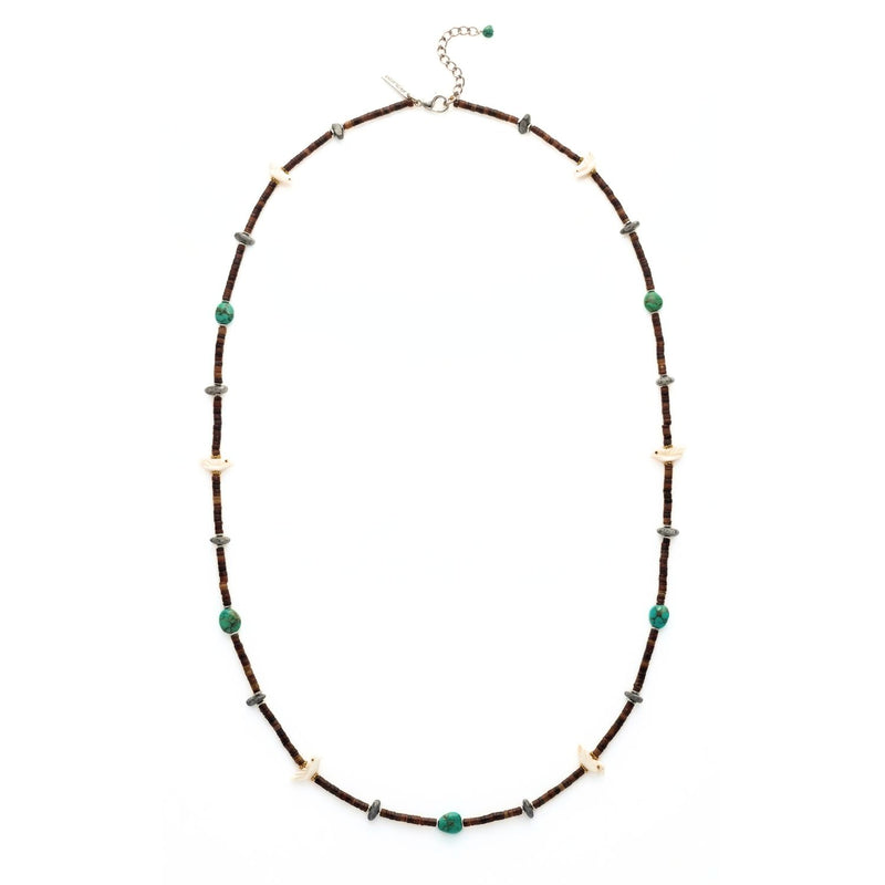 High-resolution studio product shot of the JAREDJAMIN Kai Necklace laid out in an oval configuration against a crisp white backdrop, showcasing the dark natural horn discs, turquoise pebbles, matte hematite stones, carved bird charms, and the sterling silver extension chain with clasp.