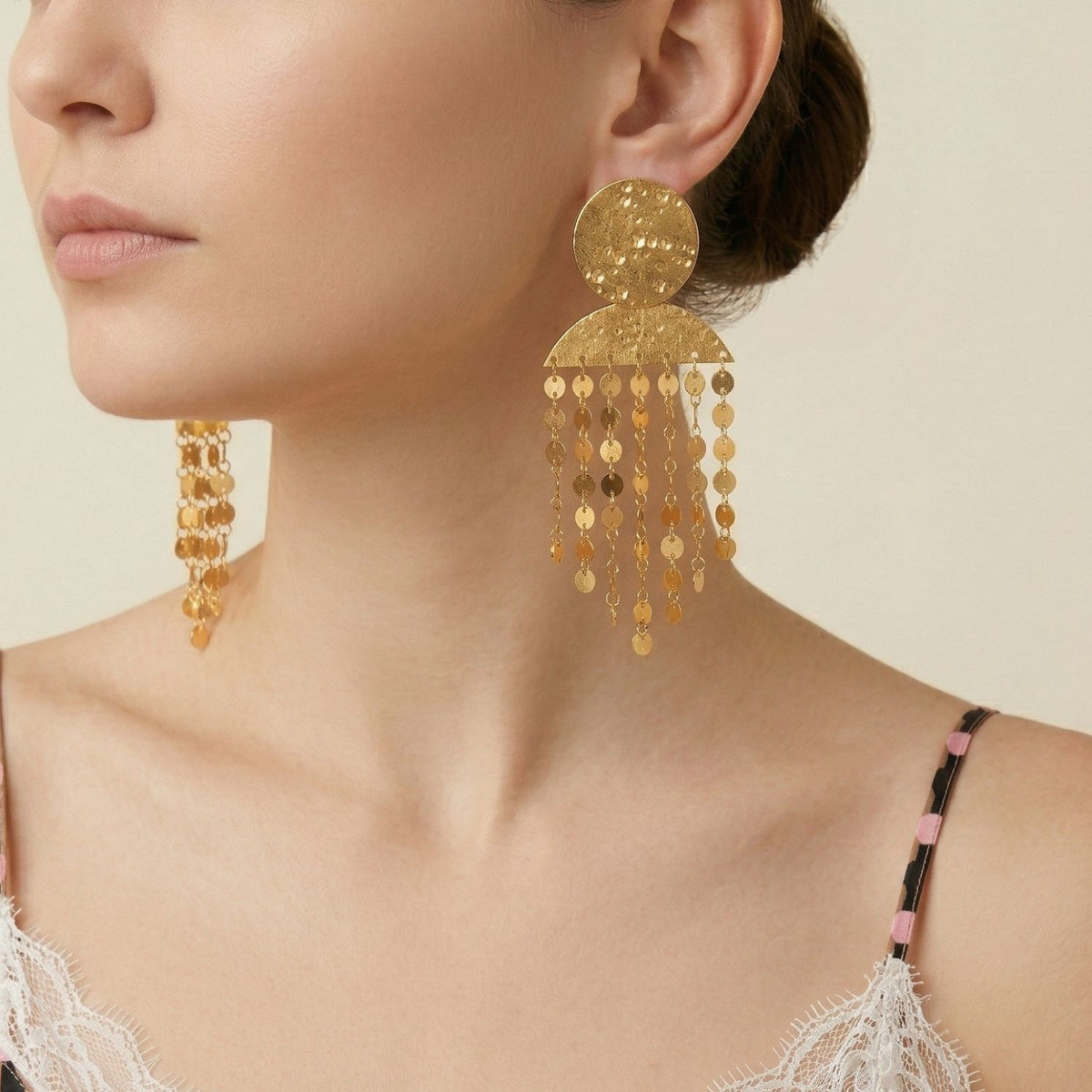 A woman in a lace-trimmed camisole punctuates her look with Koren Clip On Earrings—hand-assembled in our West Hollywood studio, sculpted gold plate forms, and dropped beads. Small-batch and eco-conscious. Style Note: transitions from tailored blazers to silk slip dresses.
