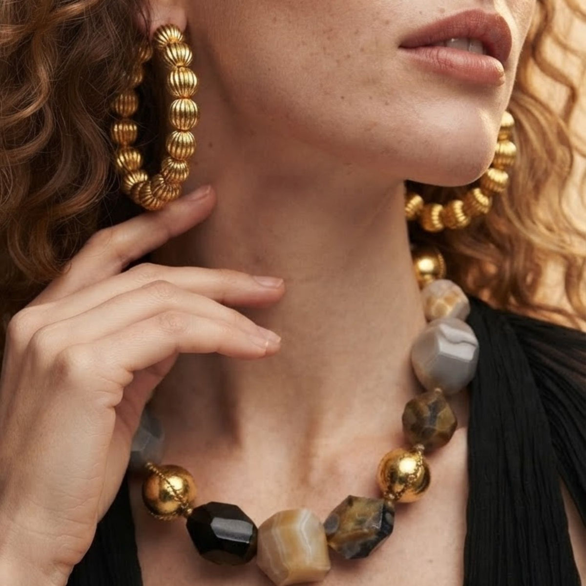 Side profile portrait of a model wearing the Large Gold Lantern Hoop Earrings and statement necklace, demonstrating their comfortable drop and presence along the jawline.