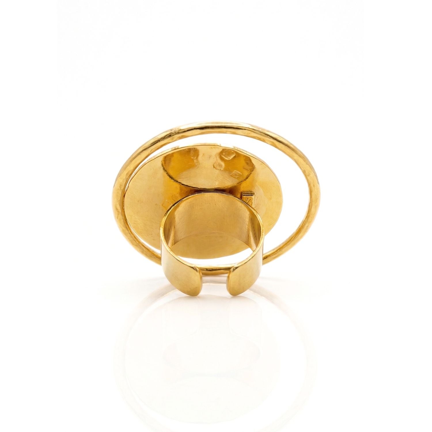 The Large Peacock Eye Ring by JAREDJAMIN Jewelry Online features a hammered brass disc at the center, framed by a slim, smooth band. This adjustable gold ring shines against a plain white background with its eye-catching reflective finish.