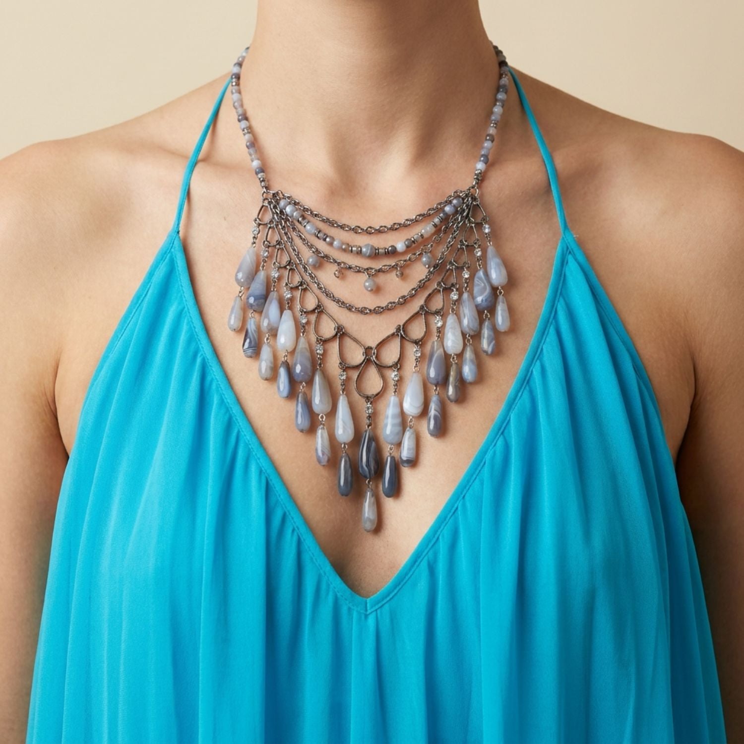 High-resolution studio product shot of the JAREDJAMIN Cordelia Bib Necklace laid out flat against a white backdrop, showcasing the round agate collar strand, the layered silver chains, and the detailed multi-tonal grey agate teardrop fringe.