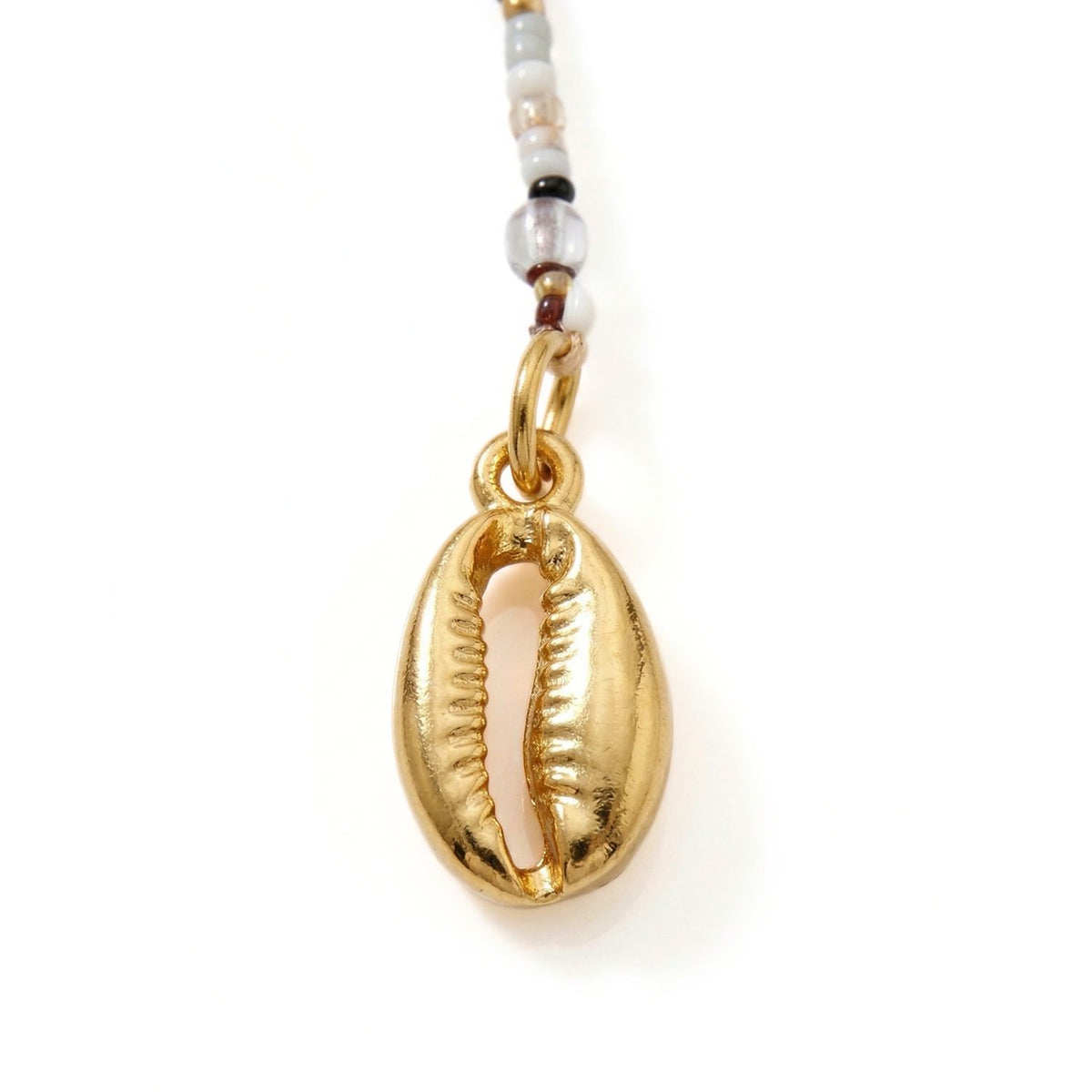 The Malibu Cowrie Shell Necklace by JAREDJAMIN Jewelry Online highlights its gold cowrie shell pendant with a ridged, shiny finish as the focal point, hanging from a beaded necklace of white, clear, and brown tones for a boho vibe.