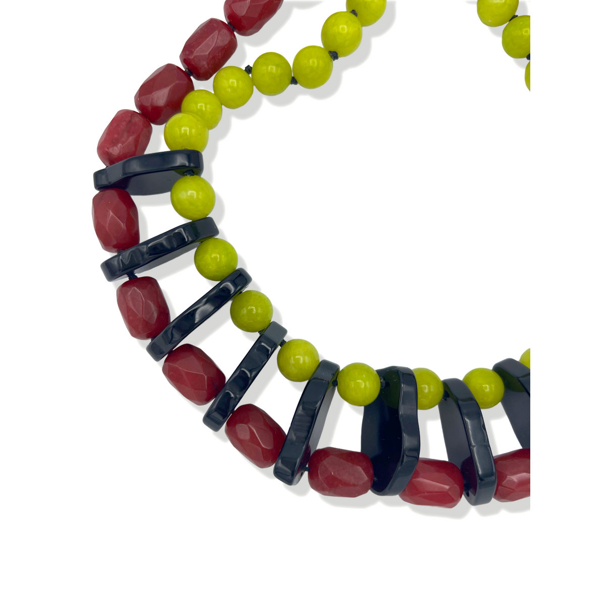 The Modern Mix Gemstone Necklace by JAREDJAMIN Jewelry Online features red faceted beads, glossy lime green rounds, and curved black spacers in a repeating pattern with a sterling silver lobster clasp, displayed on a white background.