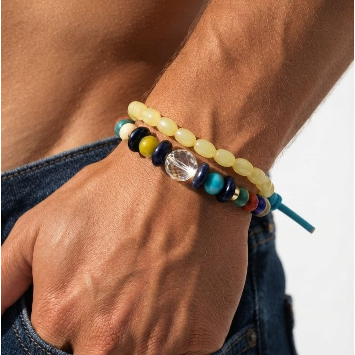 Close-up profile of a man's wrist wearing the Elio Repurposed Glass Bead Bracelet Stack, illustrating its multi-tonal scale, stacked texture, and casual aesthetic paired with denim.