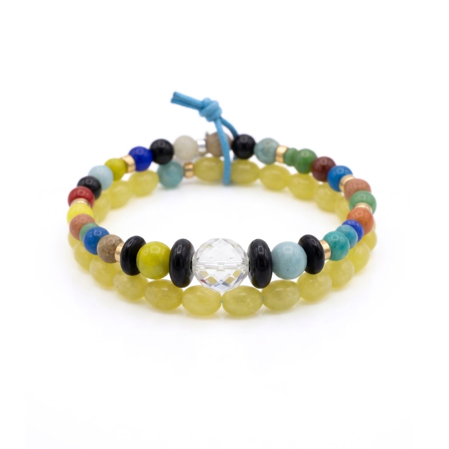 High-resolution studio product shot of the JAREDJAMIN Elio Men's Bracelet Set laid flat on a white backdrop, detailing the limoncello yellow bead strand, the multicolored strand with its central faceted glass focal, and the blue leather knot tie.