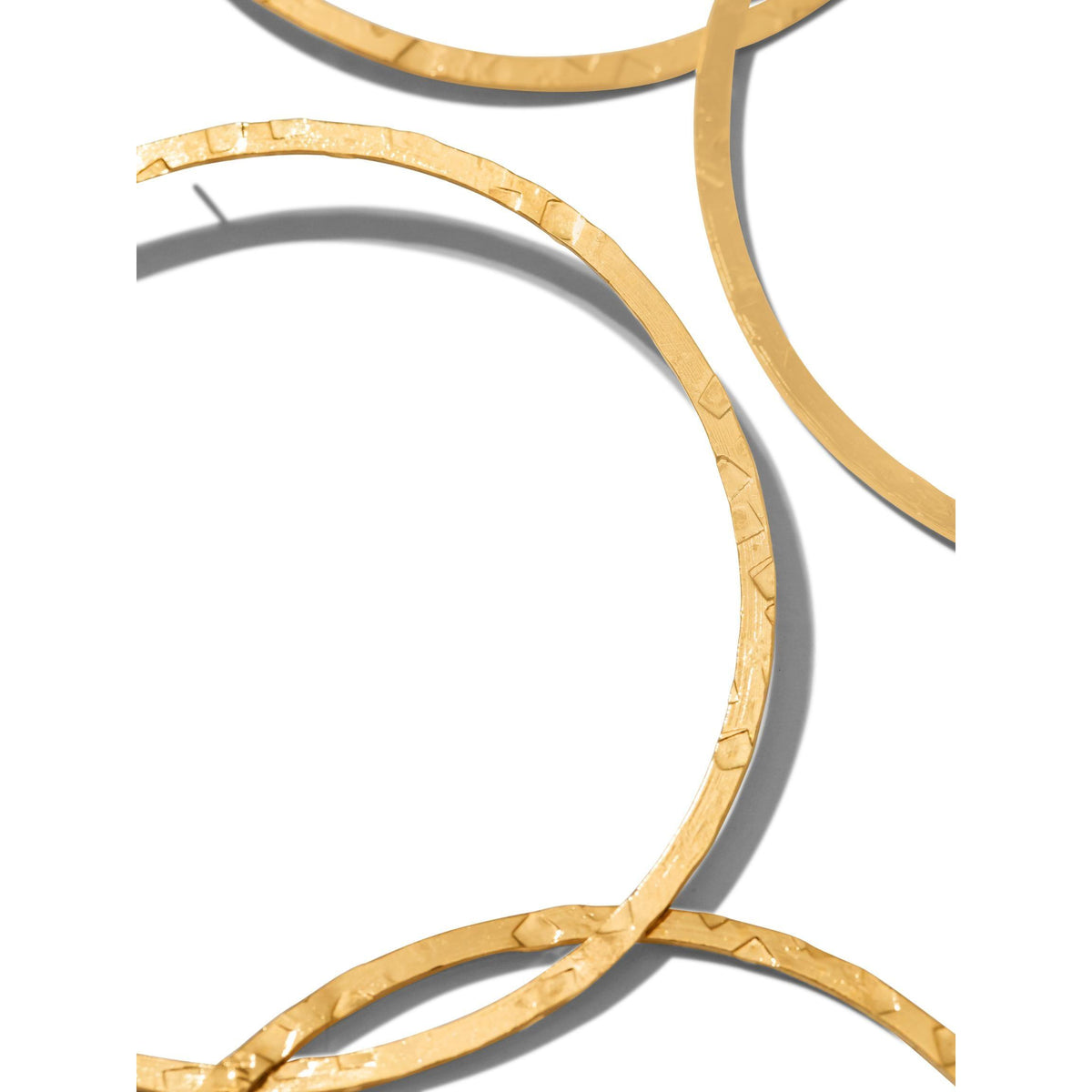 gros plan of three overlapping or Raquel Dangle créole Post boucles d'oreilles par JAREDJAMIN Bijoux en Ligne. Les 18K plaqué or créoles have a hammered, reflective finish, montré sur a fond blanc avec shadows highlighting their unique shape.