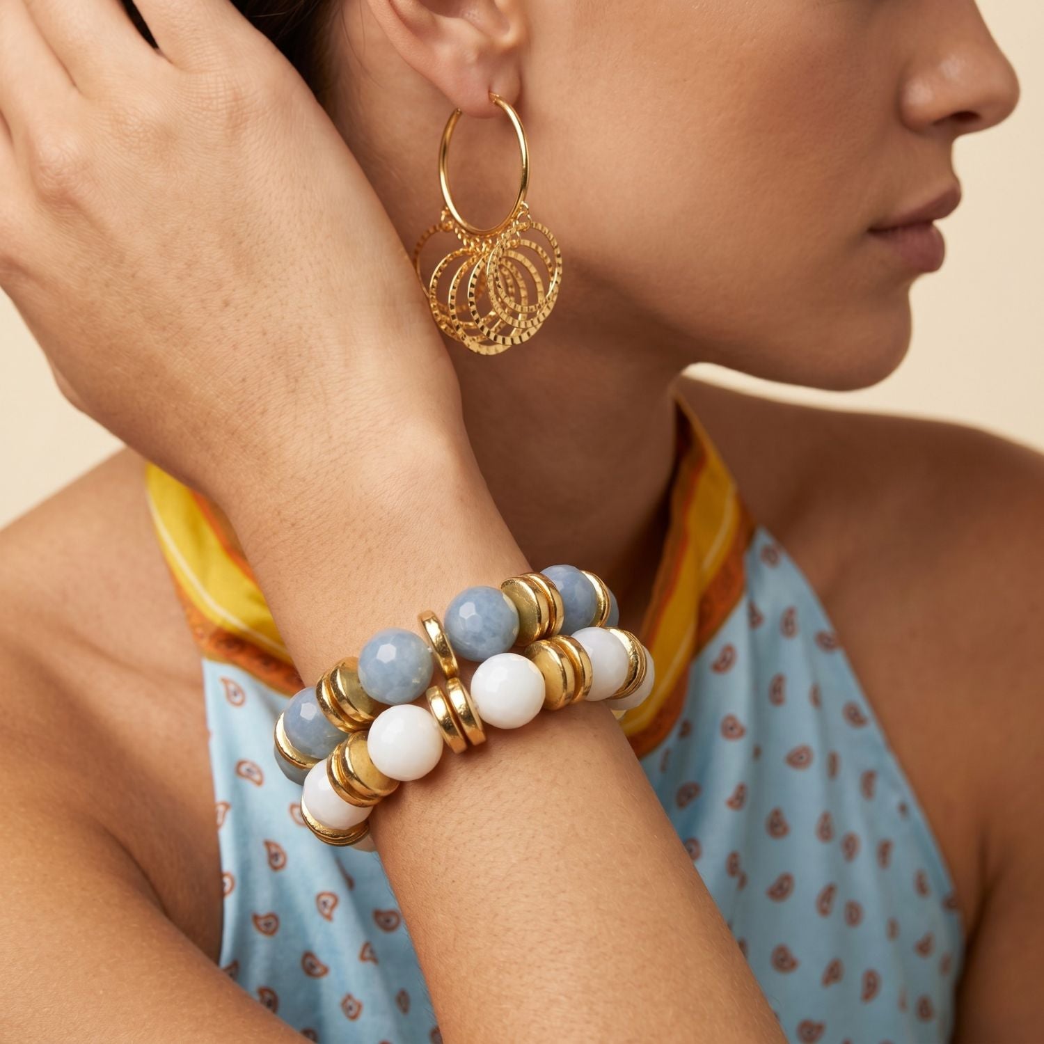High-resolution studio product shot of the JAREDJAMIN Olivia stretch bracelet variant featuring large 16mm faceted sky-blue aquamarine round gemstones and high-polish 18k gold-plated disc accent beads.