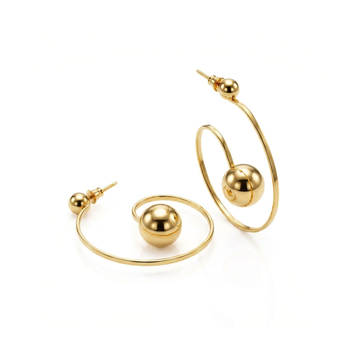 Angled studio layflat shot of the 18k gold-plated Orbita Swirl earrings on a white surface, showcasing the post fastening integrated into the top sphere and the depth of the larger central sphere.