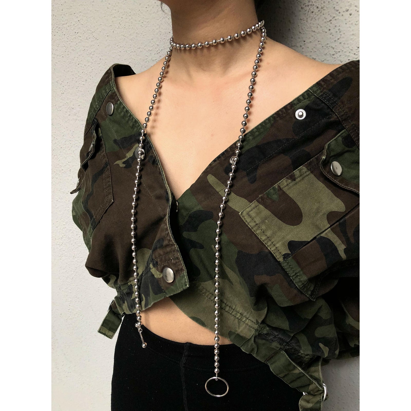 The Silver Constellation Orbita Necklace by JAREDJAMIN Jewelry Online features reflective silver spheres and a toggle clasp with a circular hoop and bar, laid flat in a gentle loop on a white background.