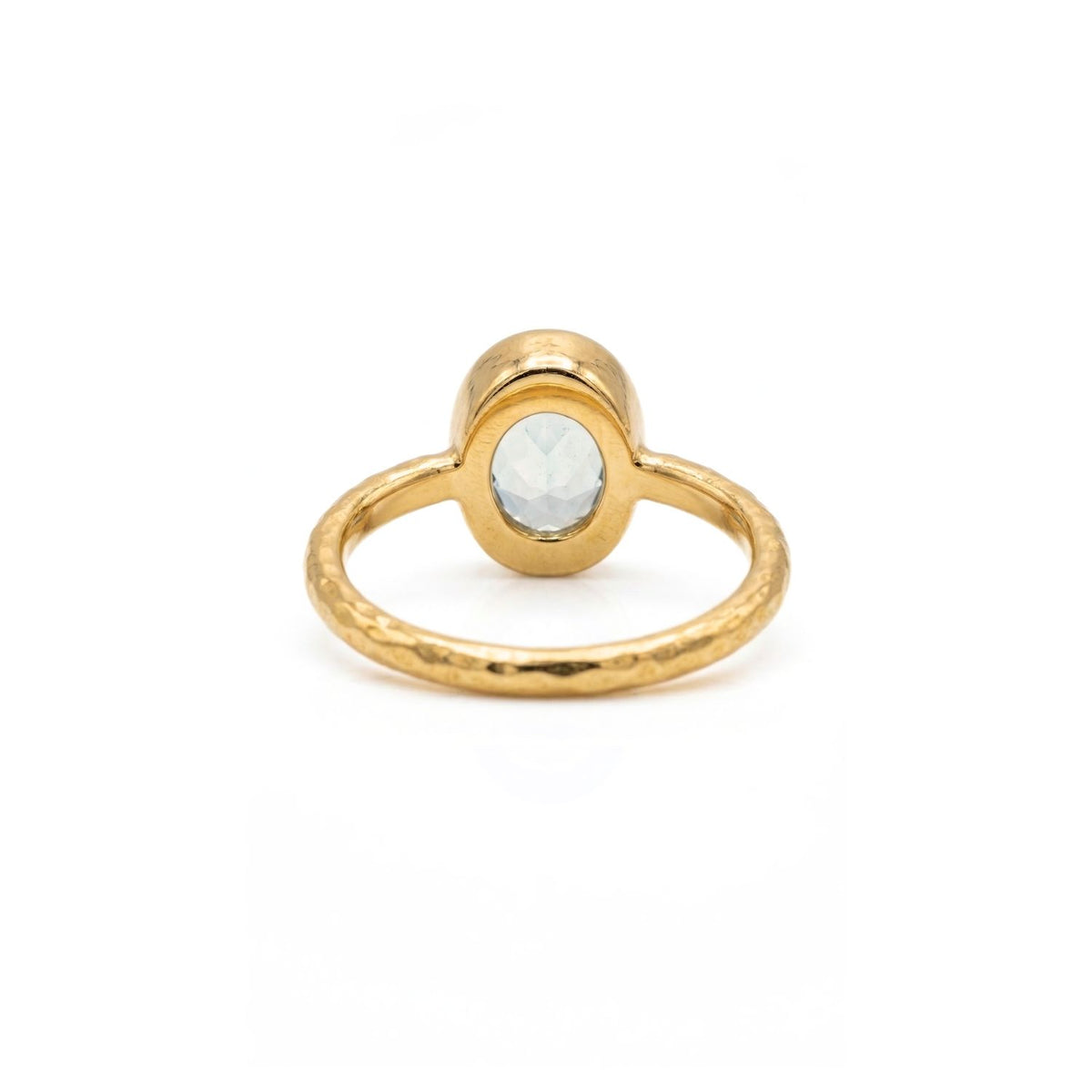 The Oval Aquamarine Gemstone Ring by JAREDJAMIN Jewelry Online features a faceted light blue gemstone set in a hammered 18K gold-plated band, shown on a plain white background.