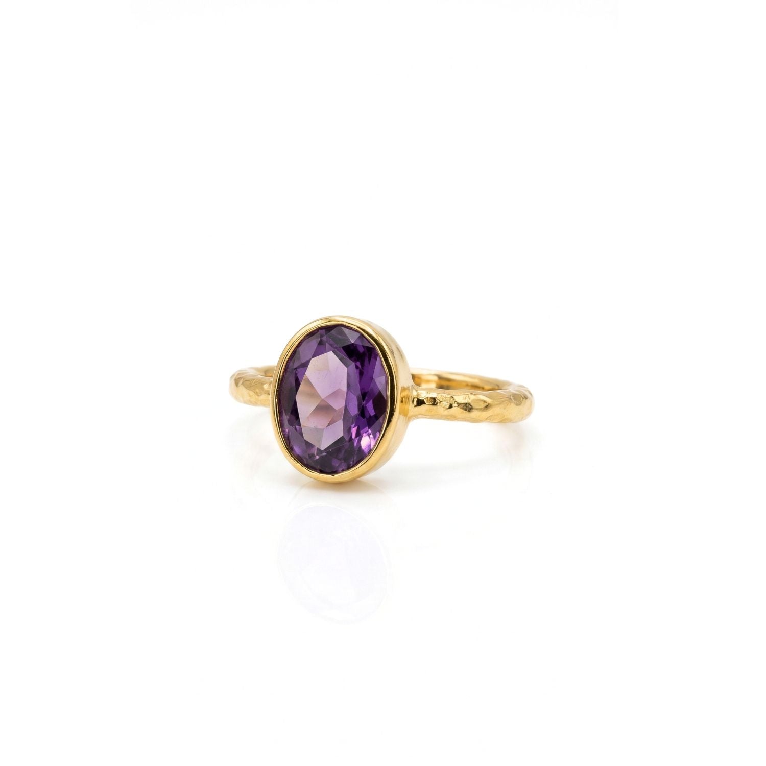 The JAREDJAMIN Jewelry Online Oval Amethyst Gemstone Ring features a faceted purple gemstone in a simple bezel setting with a textured band, crafted from sterling silver with 18K gold plating and shown on a white background.