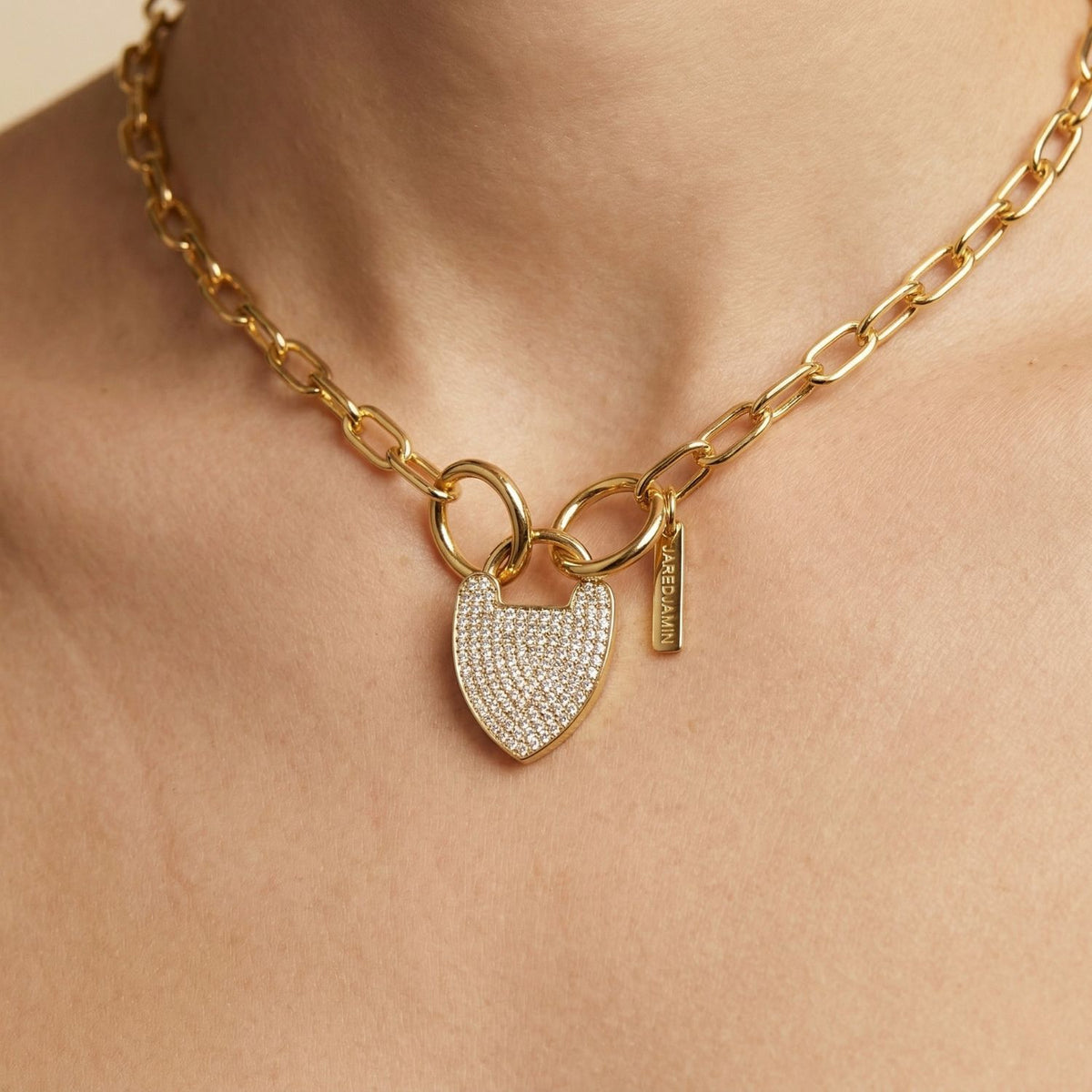 Hand-assembled in our West Hollywood studio, this gold chain necklace captures small-batch craft with a heart-cut Cubic Zirconia, engraved tag, and pavé padlock clasp. Eco-conscious and refined. Style Note: anchors crisp shirts or glides into evening.