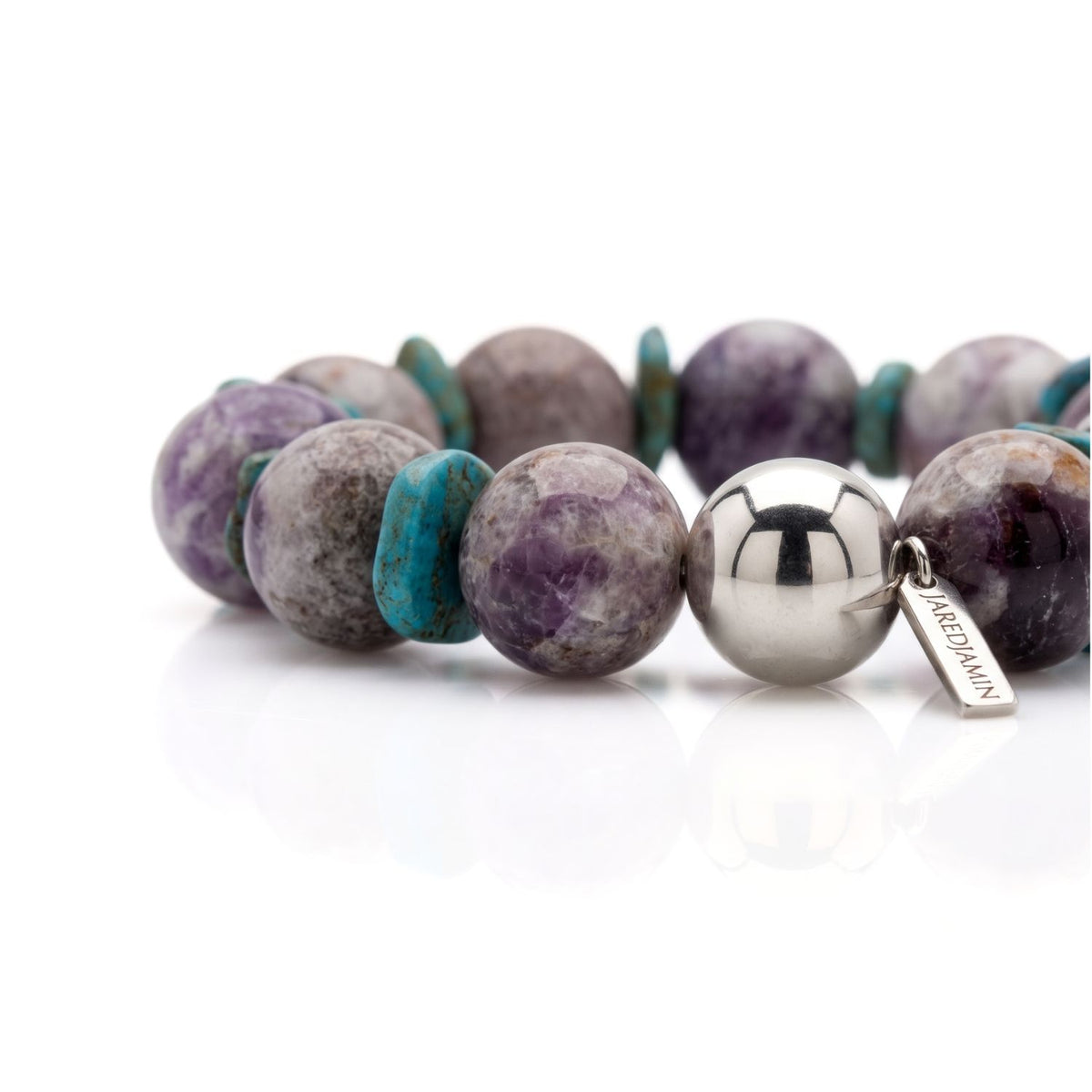 Close-up studio shot focusing on the polished 14mm silver-plated sphere and JAREDJAMIN logo tag alongside 16mm cloudy amethyst beads and turquoise howlite disc spacers.