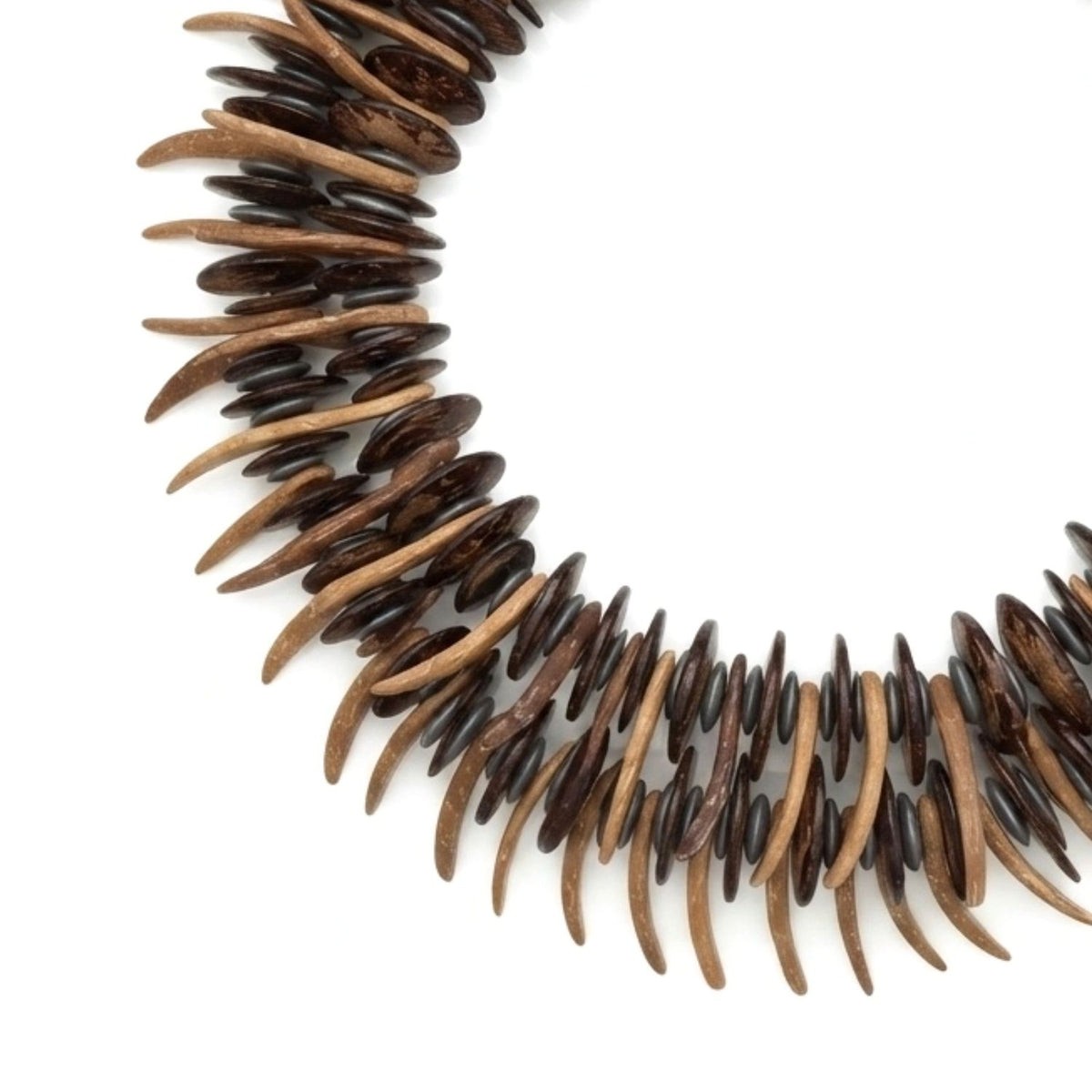 Macro studio detail shot focusing on the hand-knotted construction, alternating silver-matted hematite discs, brown coconut discs, and extended wooden spike beads.