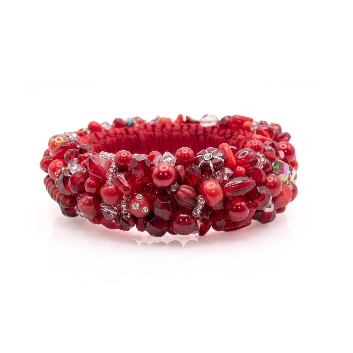 High-resolution, sharp e-commerce flat lay photography shot directly from above using a Canon EOS 5D Mark IV with a macro lens, featuring the JAREDJAMIN Pomegranate Princess Bangle on a white background to highlight the dense, monochromatic red embroidery of vintage glass, Lucite, and crystals.