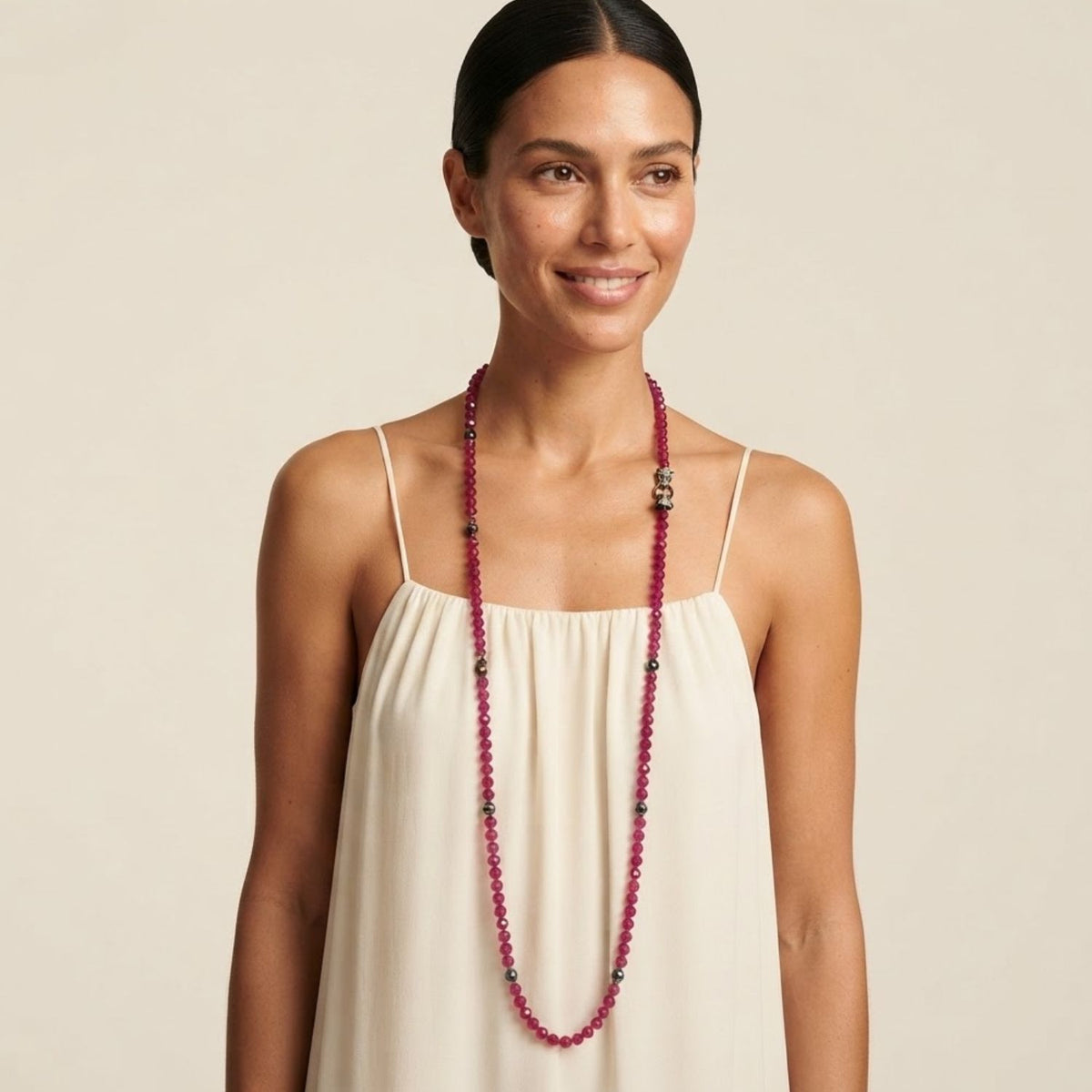 Front portrait view of a model wearing the Valeria Panther Quartz Necklace styled long at its full length over a minimalist cream silk slip dress, demonstrating its elegant scale and drape.