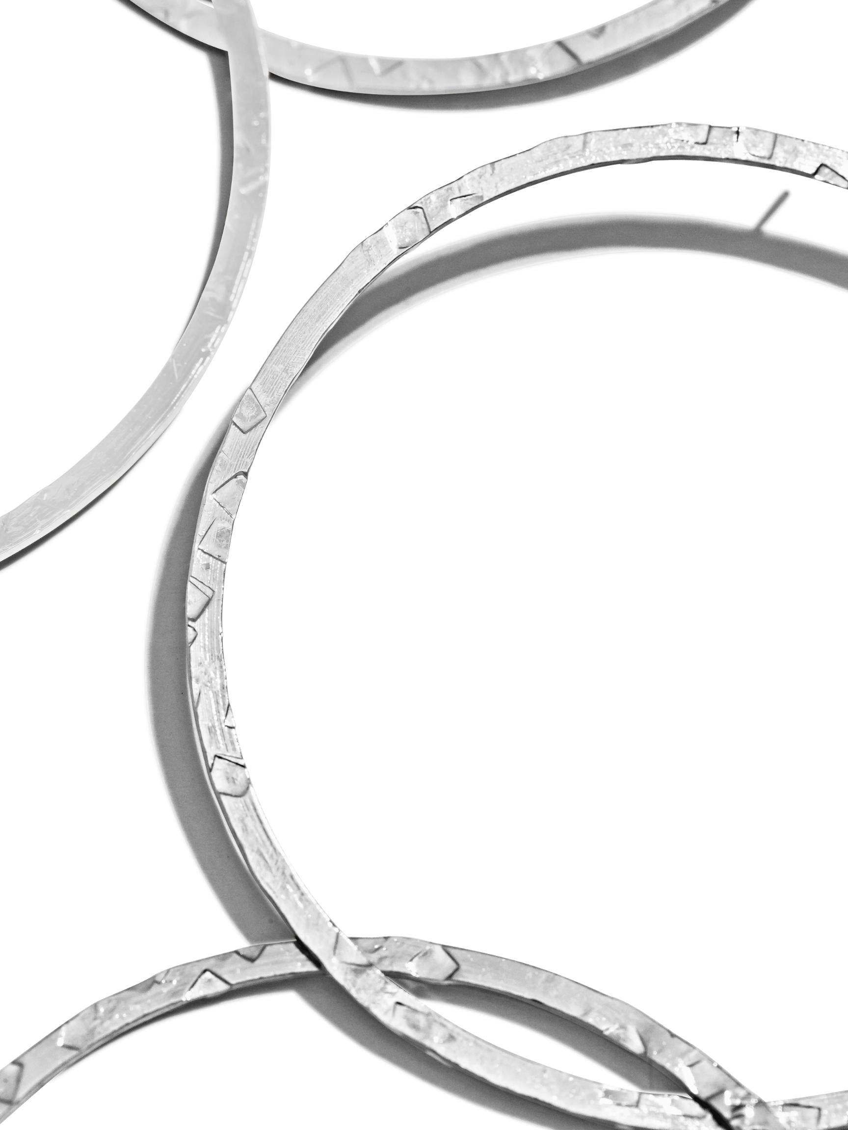 Four Silver Raquel Dangle Hoop Post Earrings by JAREDJAMIN Jewelry Online are displayed on a white background. These large earrings have a hammered texture, with two pairs side by side. Each earring features two linked hoops forming a vertical chain-like design.