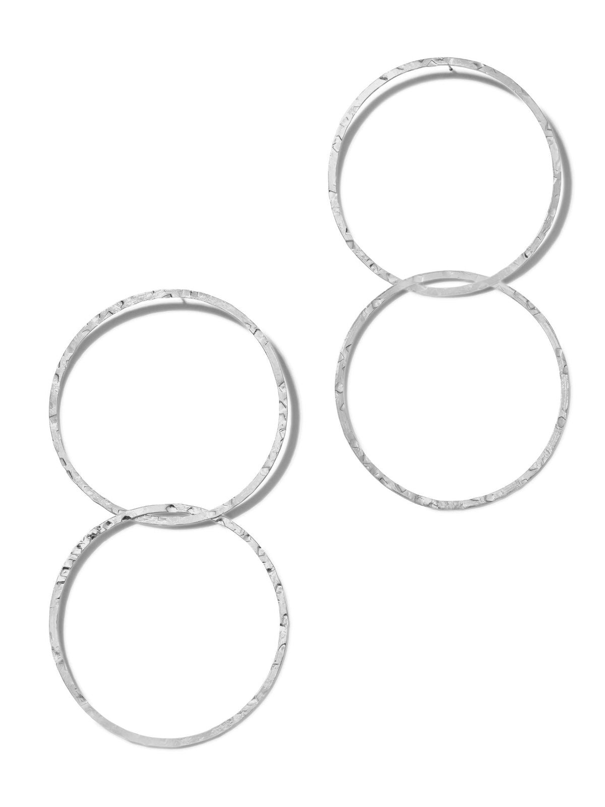 Four Silver Raquel Dangle Hoop Post Earrings by JAREDJAMIN Jewelry Online are displayed on a white background. These large earrings have a hammered texture, with two pairs side by side. Each earring features two linked hoops forming a vertical chain-like design.