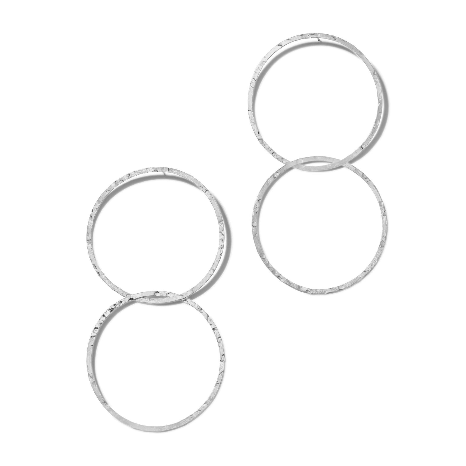 Three pairs of Silver Raquel Dangle Hoop Post Earrings by JAREDJAMIN Jewelry Online are displayed on a white background. The intertwined hoops feature a hammered, faceted silver plate finish for added texture and shine.