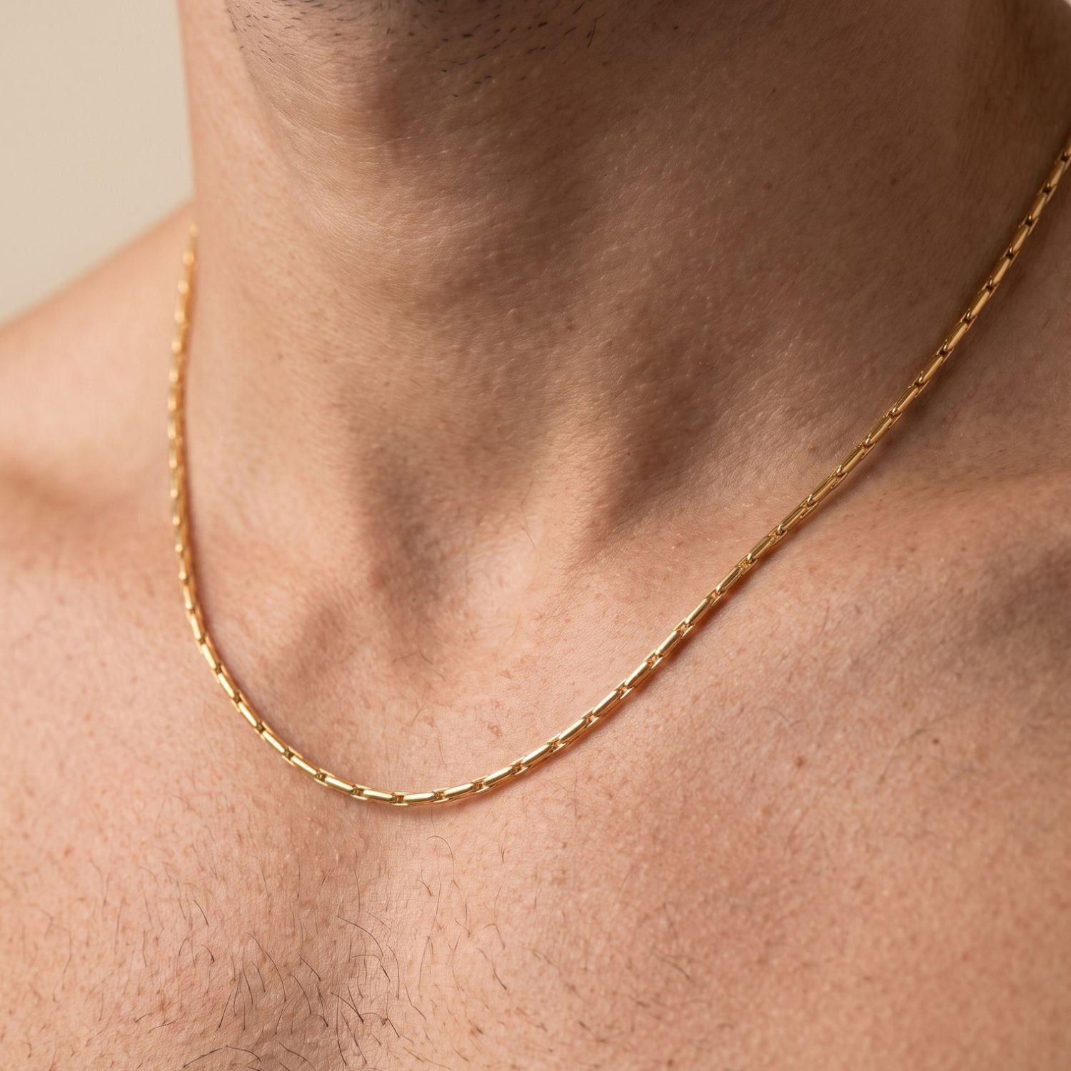 Ricky Adjustable チェーン ネックレス JAREDJAMIN製 ジュエリーオンライン is 表示された a 白い背景. This unisex snake チェーン 特徴とする a lobster clasp, extenderとラウンド チャーム,とa branded rectangular tag near clasp.