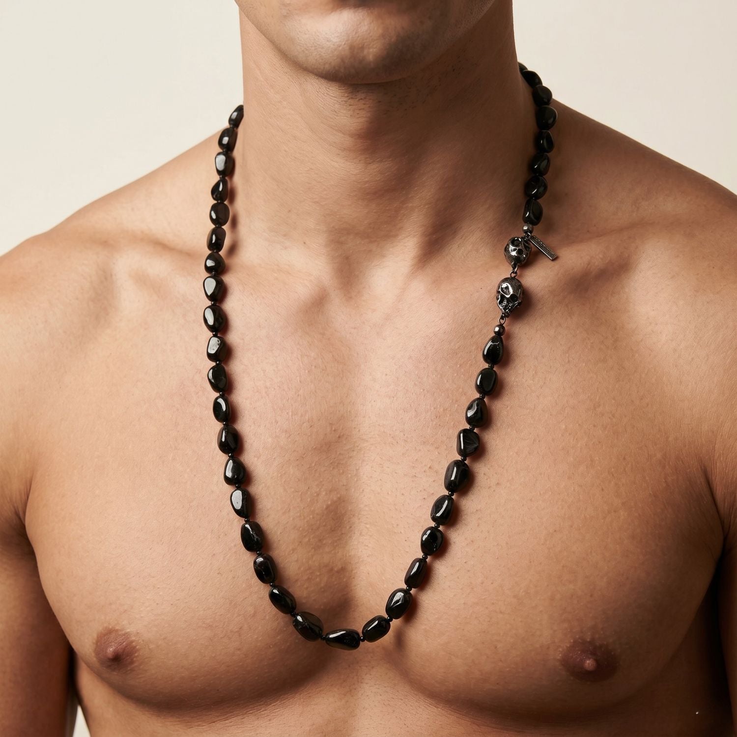 The Rocks of Sangria Skull-Clasp Necklace by JAREDJAMIN Jewelry Online features glossy, irregular garnet beads and a striking double-skull clasp on the left, creating an organic look against a plain white background.