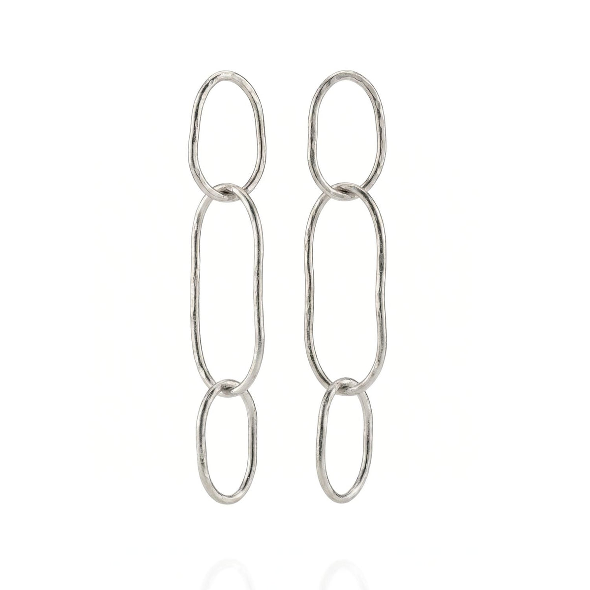 Los Shackle Link Dangle Post pendientes de JAREDJAMIN Joyería Online presentan three elongated, interlinked plata oval loops con a hammered texture for elegante style. Shown vertically sobre un fondo blanco.