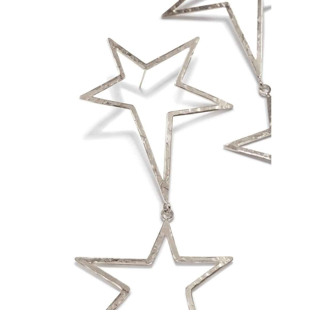 クローズアップ of JAREDJAMIN ジュエリーオンライン’s シルバー Shooting スター Dust Dangle Post イヤリング, 特徴とする hammered, hollow five-pointed stars linked together. Only parts of two イヤリング appear against a plain 白い背景.