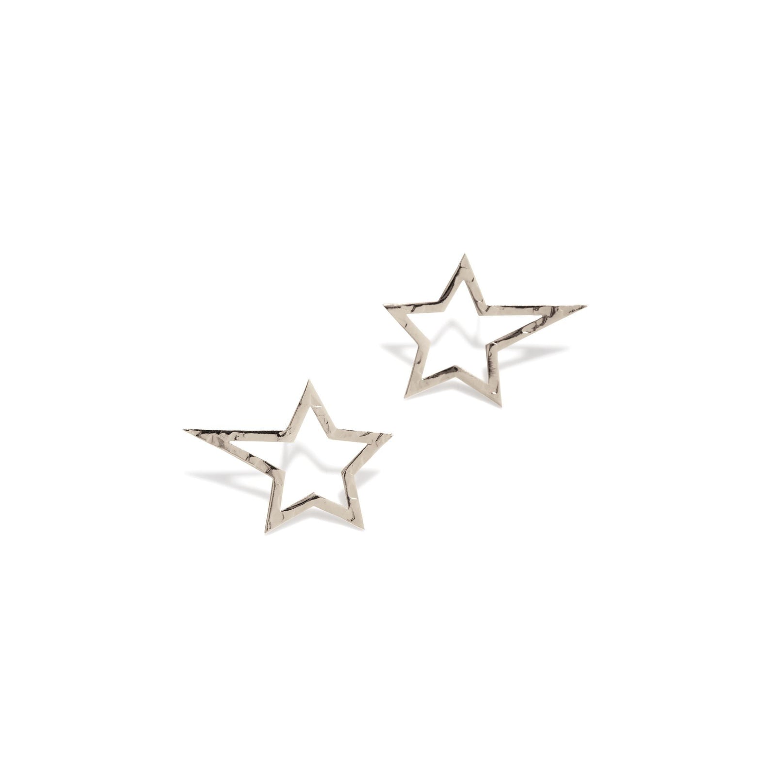 The Silver Shooting Star Dust Post Earrings Sm by JAREDJAMIN Jewelry Online are small, shiny White Bronze Plated star outline earrings with a hollow, open design, each featuring an angled five-point star against a plain white background.