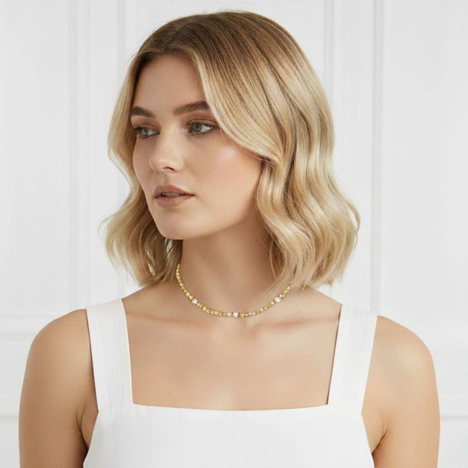 The Sand Bar Sensation Citrine Necklace by JAREDJAMIN Jewelry Online features round, translucent yellow-gold citrine beads separated by metallic gold spacers with rhinestone accents and an adjustable gold chain clasp with a rectangular tag.