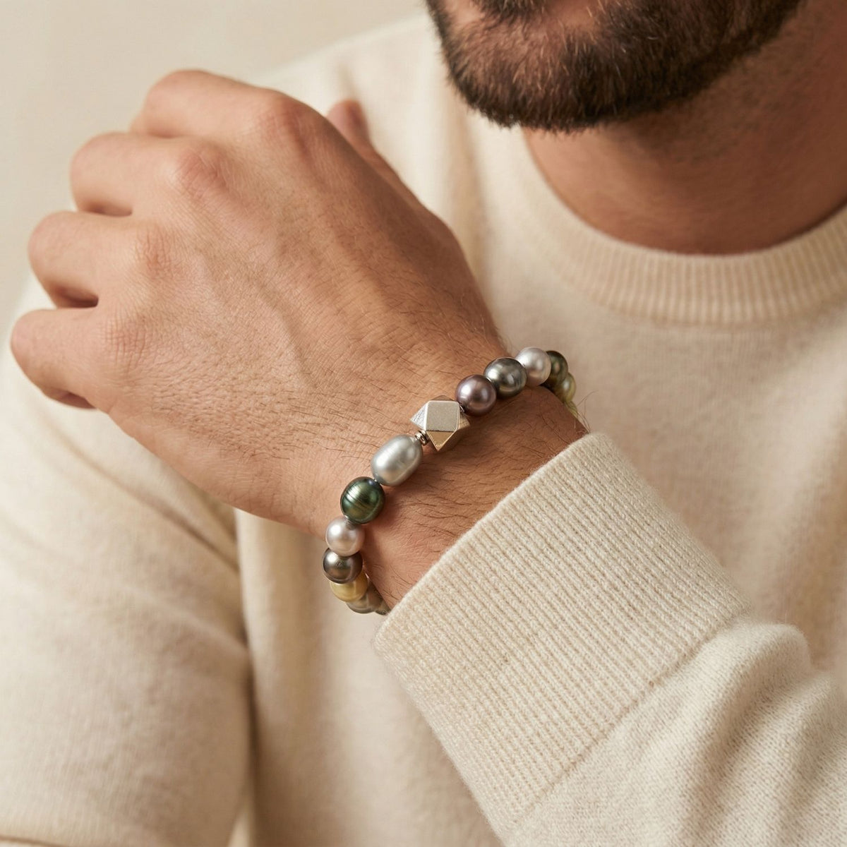 In a cream sweater, a poised wrist—lower face just out of frame—carries the Seabed Pebble Stretch Bracelet: round, hand-strung freshwater pearls and a sterling silver bead, refined in our West Hollywood studio. Small-batch and eco-conscious. Style note: Transitions effortlessly from tailored shirts to evening knits.