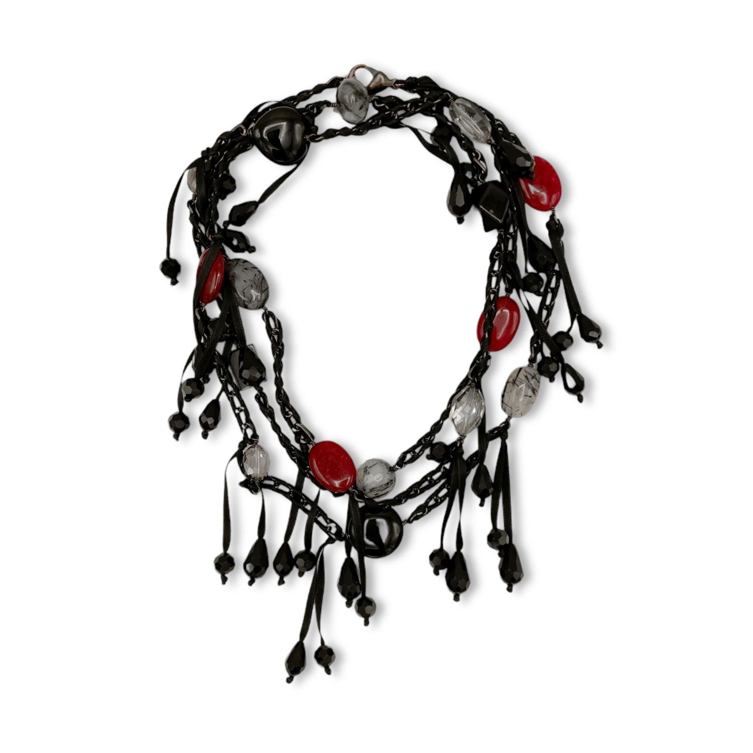 The See You Saloon Necklace by JAREDJAMIN Jewelry Online is a black twisted cord statement piece with dangling strands, bold red and clear quartz beads, plus assorted black beads. Its layered look features eclectic knots and bead clusters.