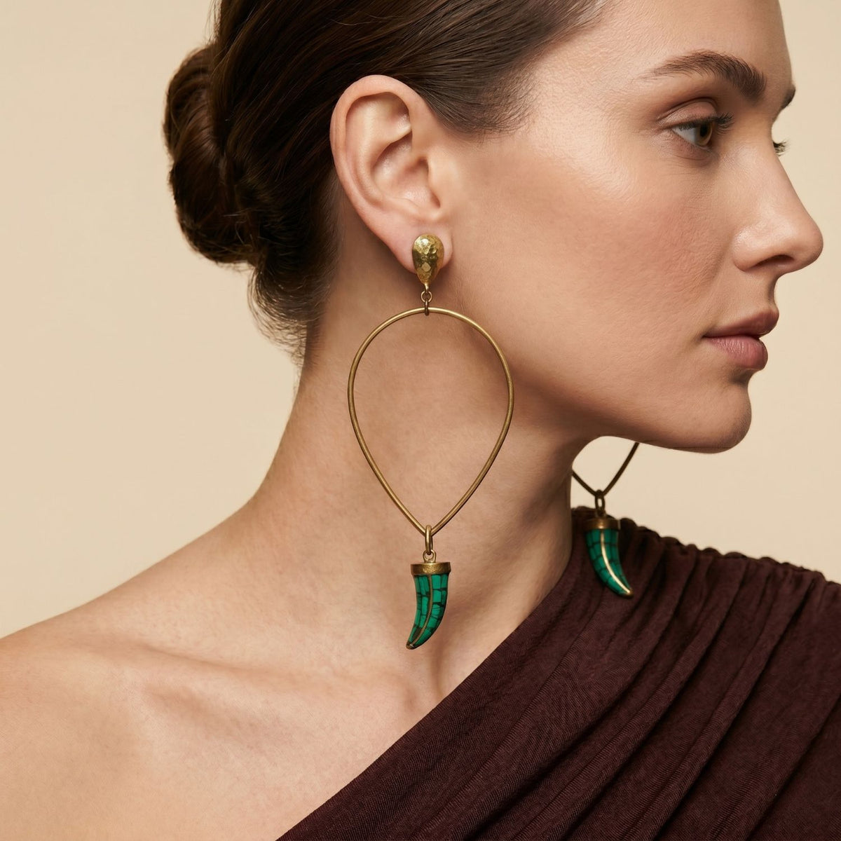 A model wearing the dramatic 4.5-inch Sierra Antique Brass Earrings, highlighting their elongated scale, warm golden hue, and vibrant turquoise accents.