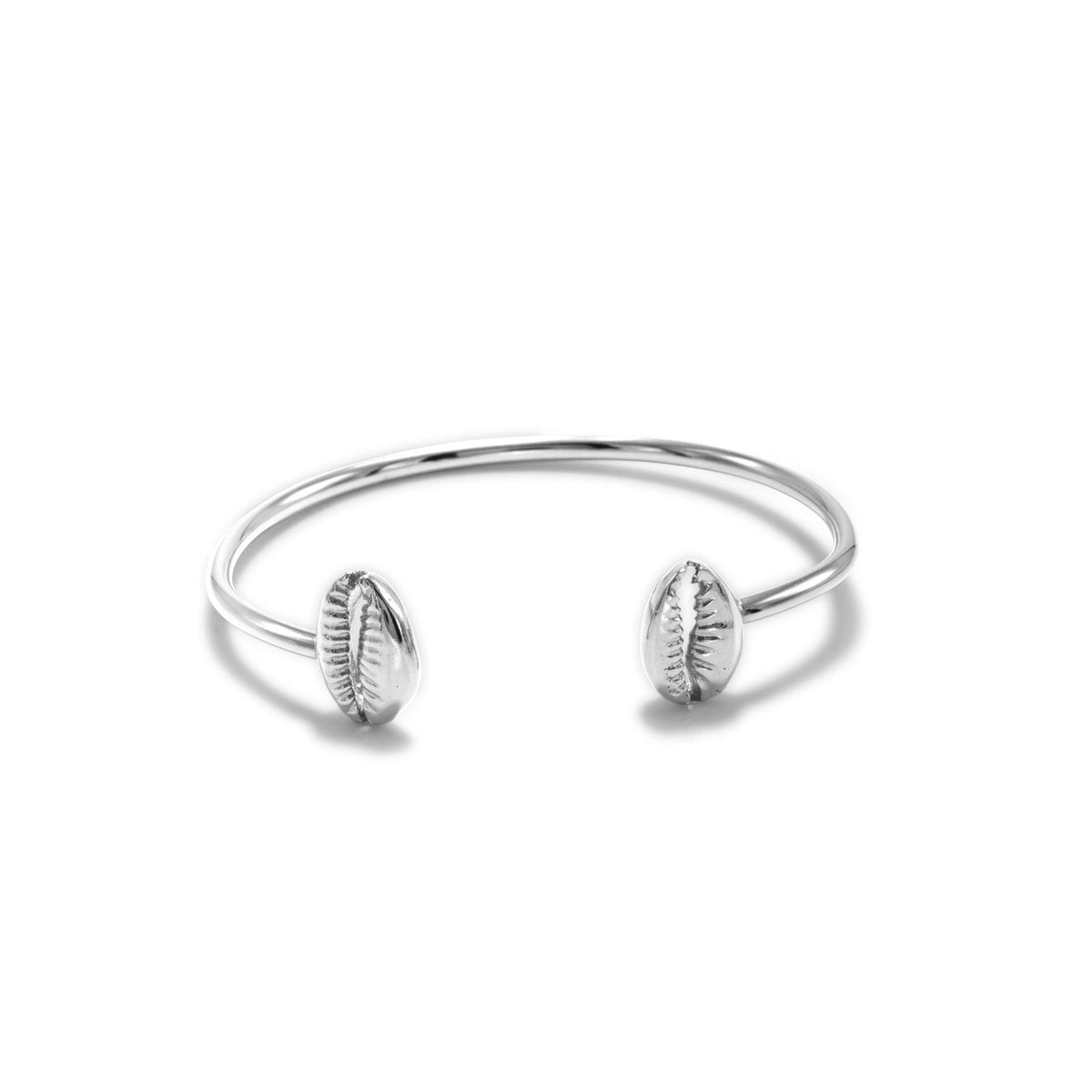 JAREDJAMIN ジュエリーオンライン シルバー Cowrie Shell カフ ブレスレット 特徴とする two detailed cowrie shell ends の上の ミニマリスト シルバー band, displayed against a plain 白い背景.