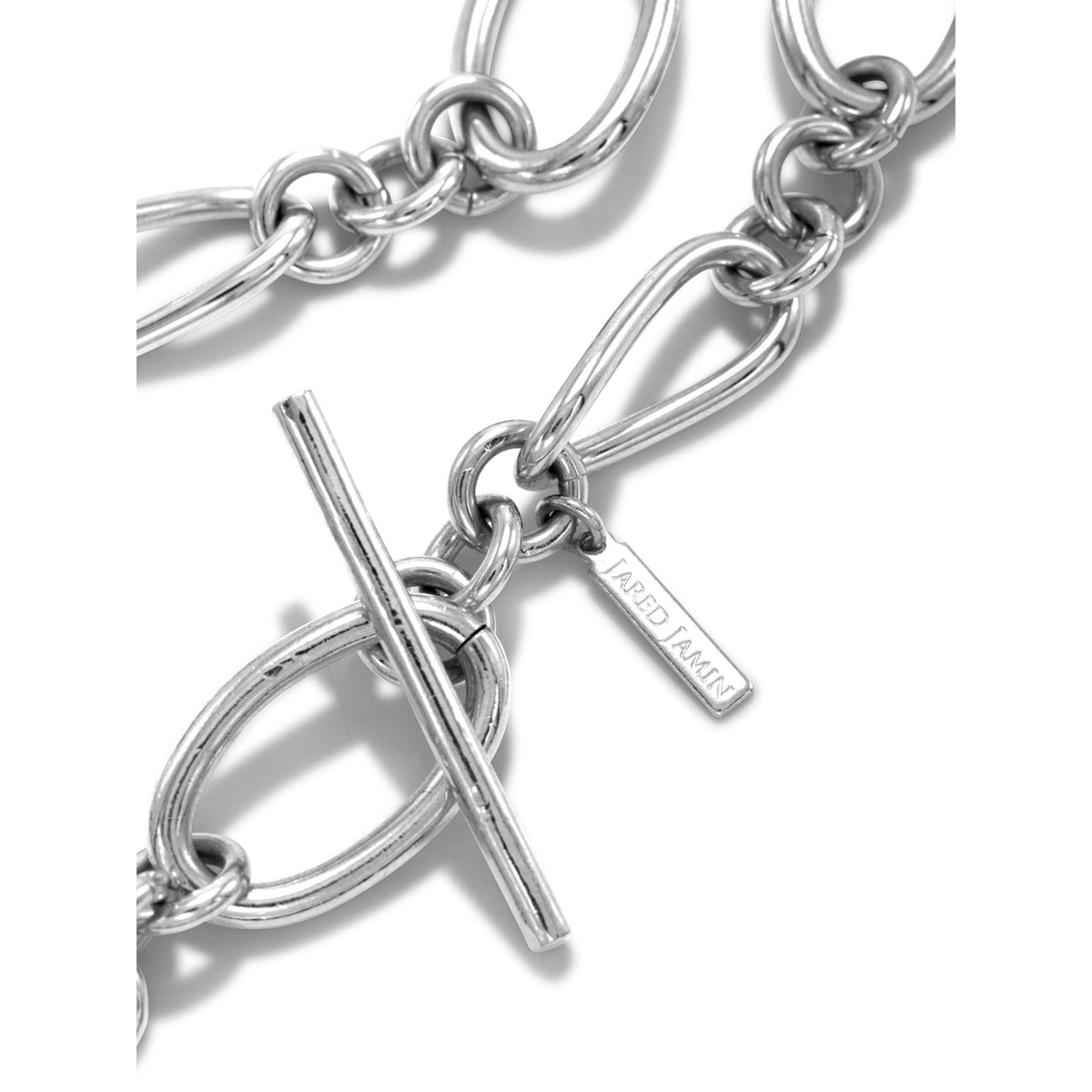 primer plano of the plata Ophelia Choker cadena collar de JAREDJAMIN Joyería Online, con large oval links, pulido plata plating, a toggle clasp, y a small rectangular tag engraved con the brand name.